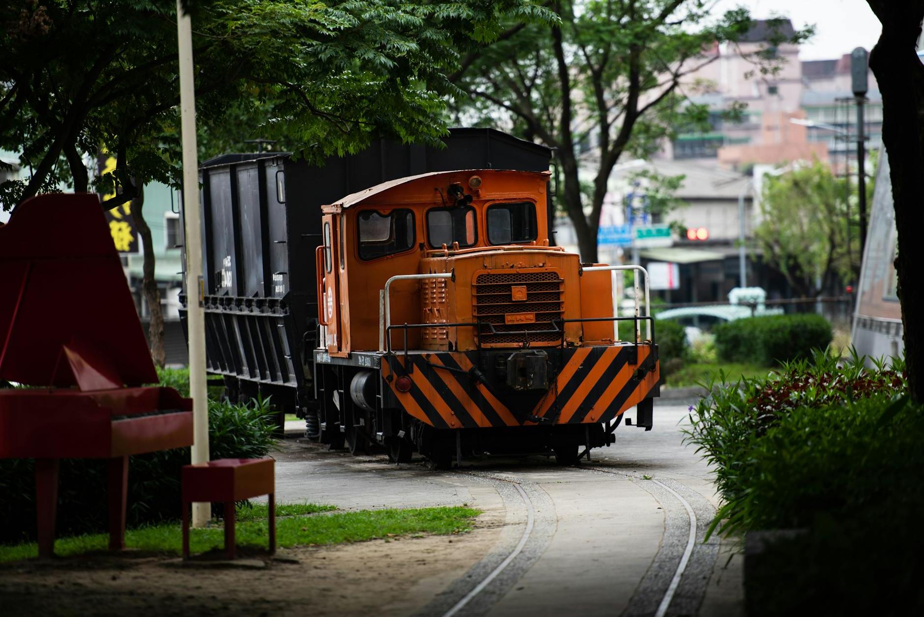 Orange and Black Train on Rail Road in the Park