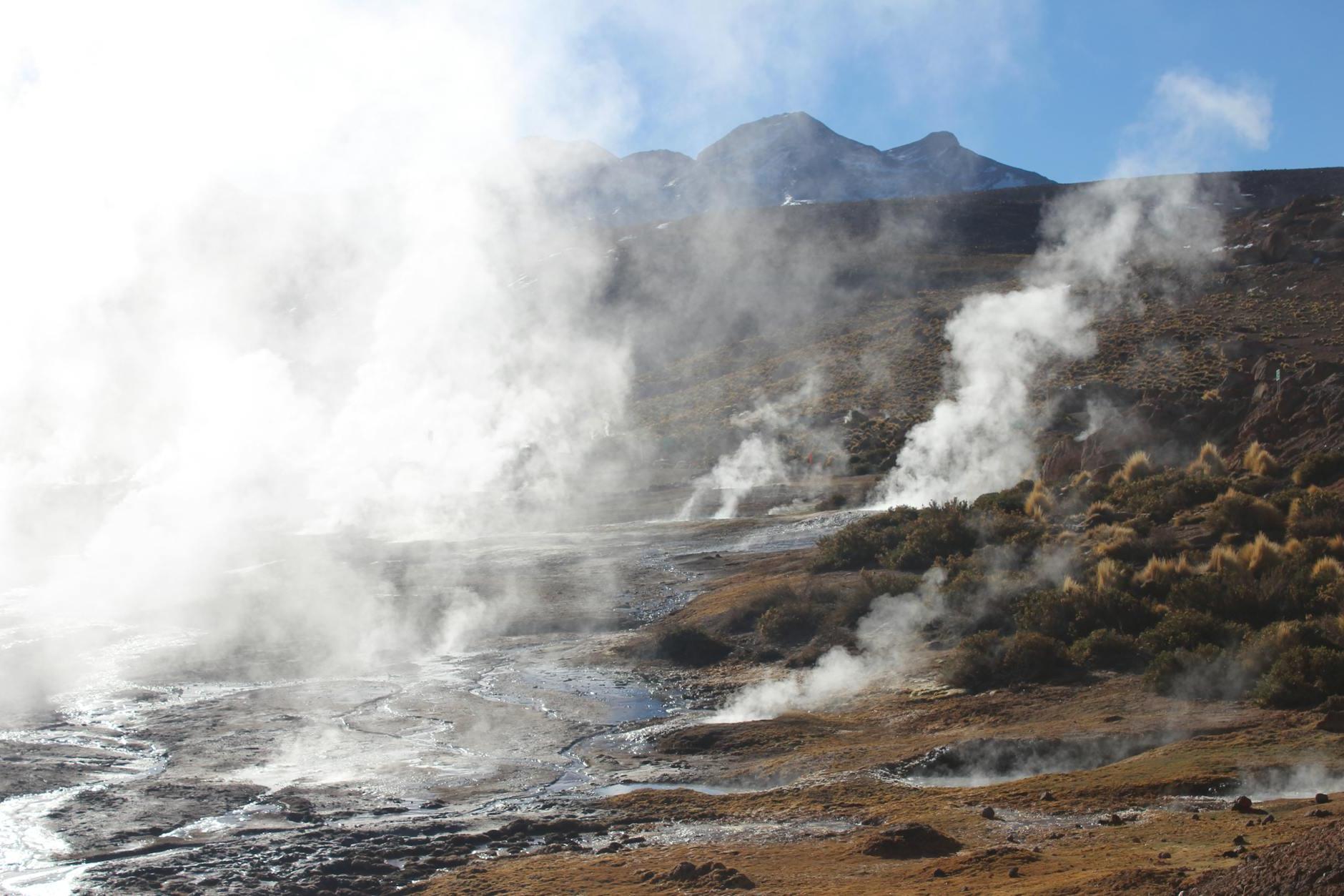 Rocky Mountains and Steaming Geysers on a Field