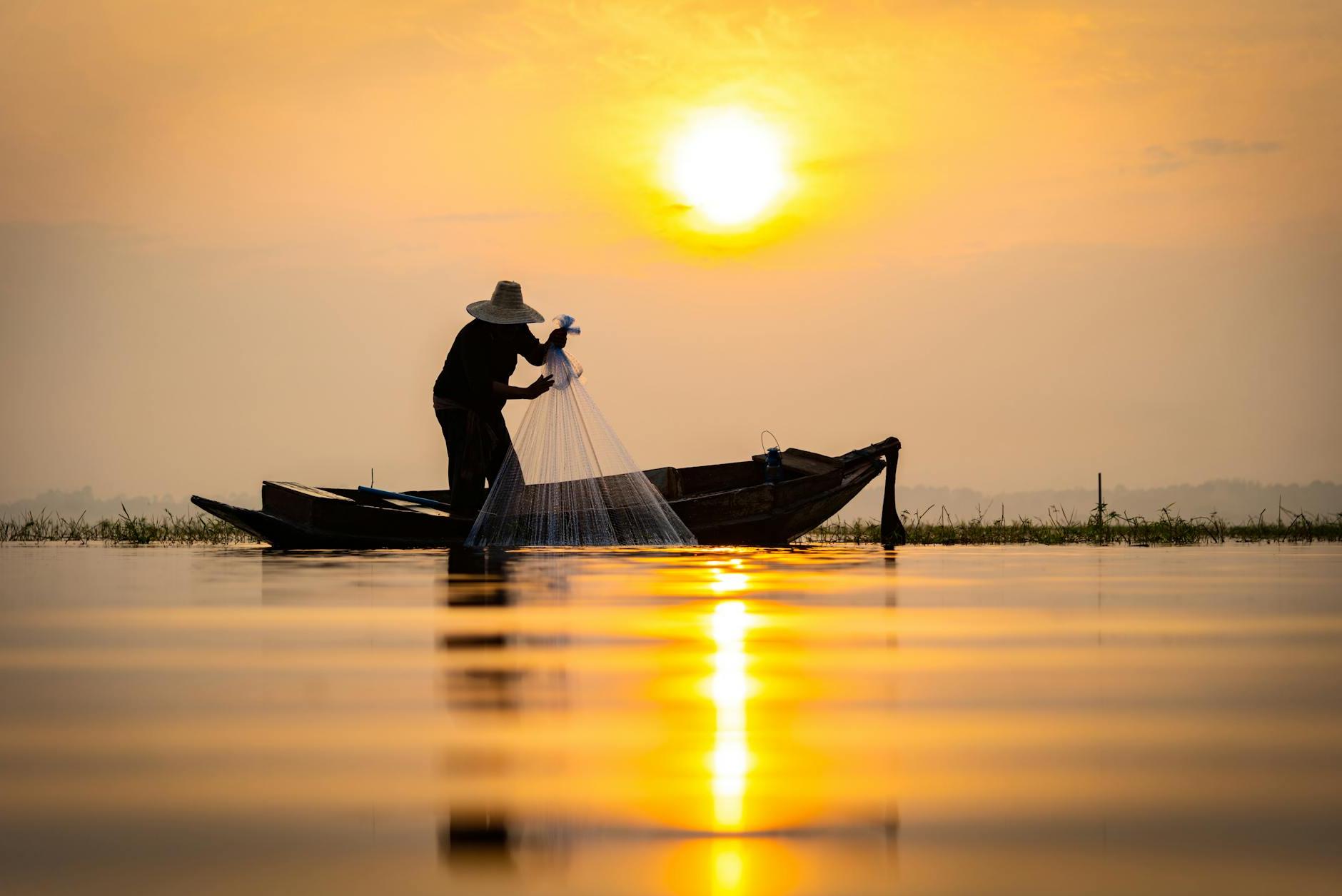 Sun Setting over a Fisherman Pulling Out a Fishing Net