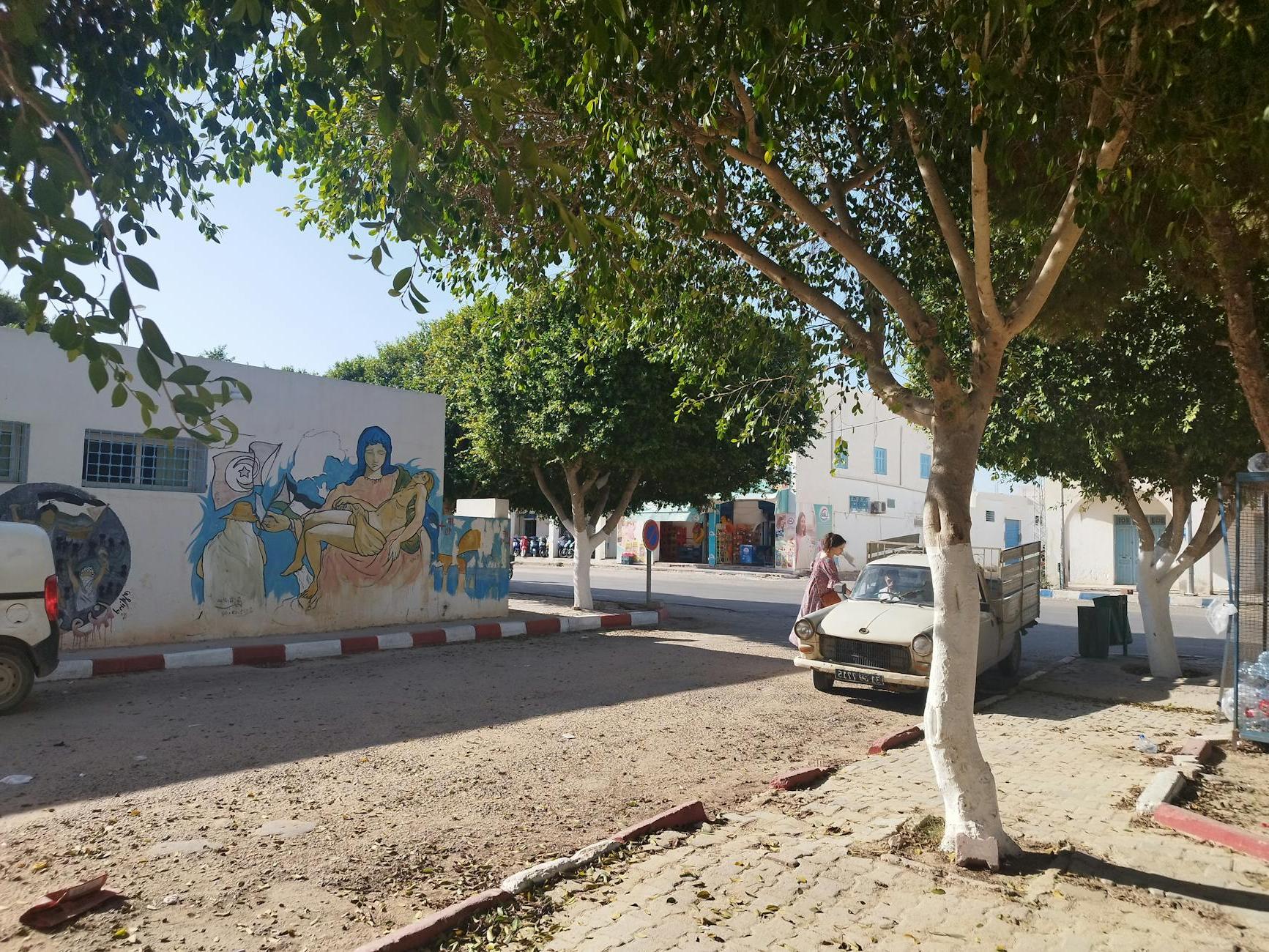 A Street in a Town with Murals on the Buildings