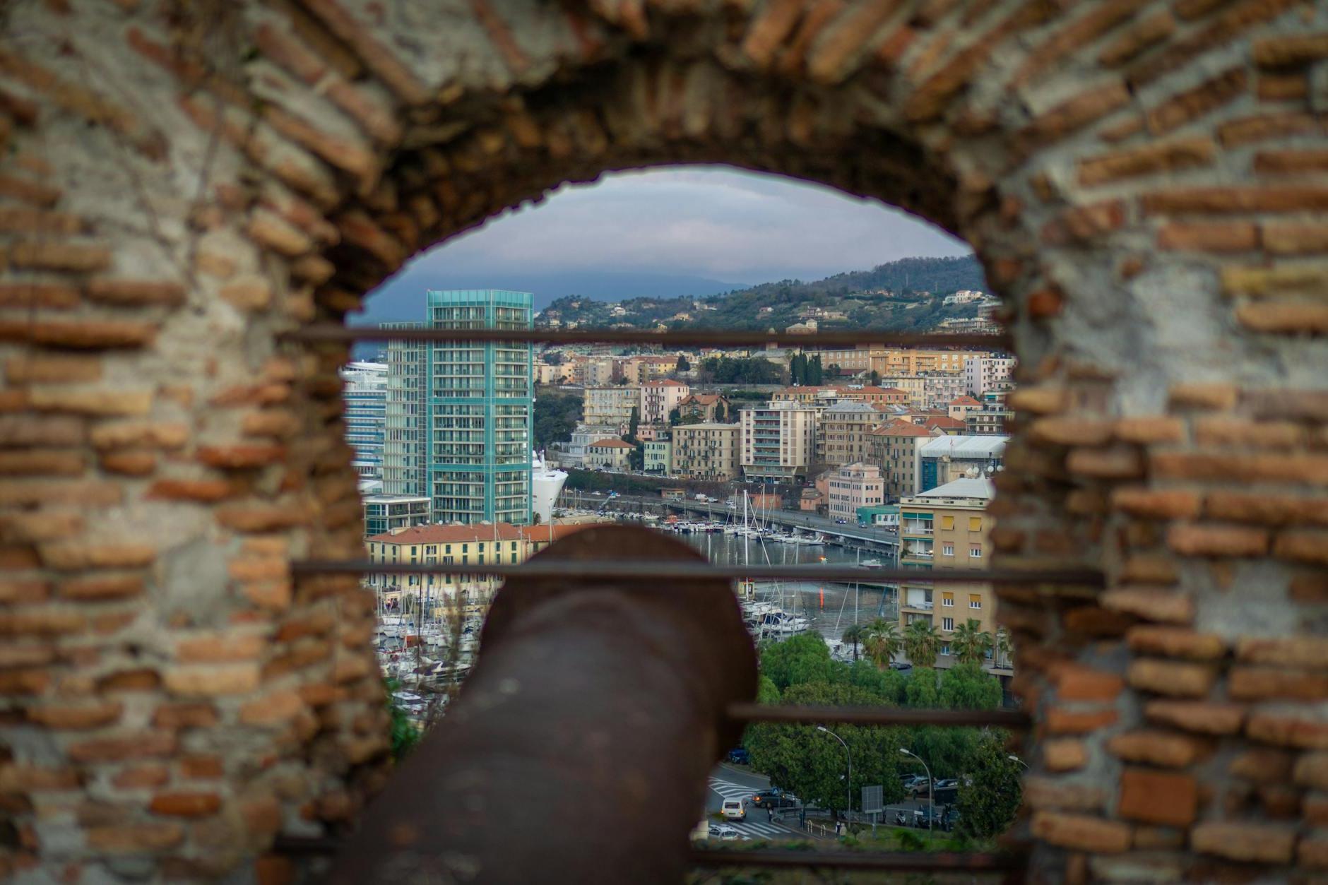 Antique Cannon with a City Harbor in the Background