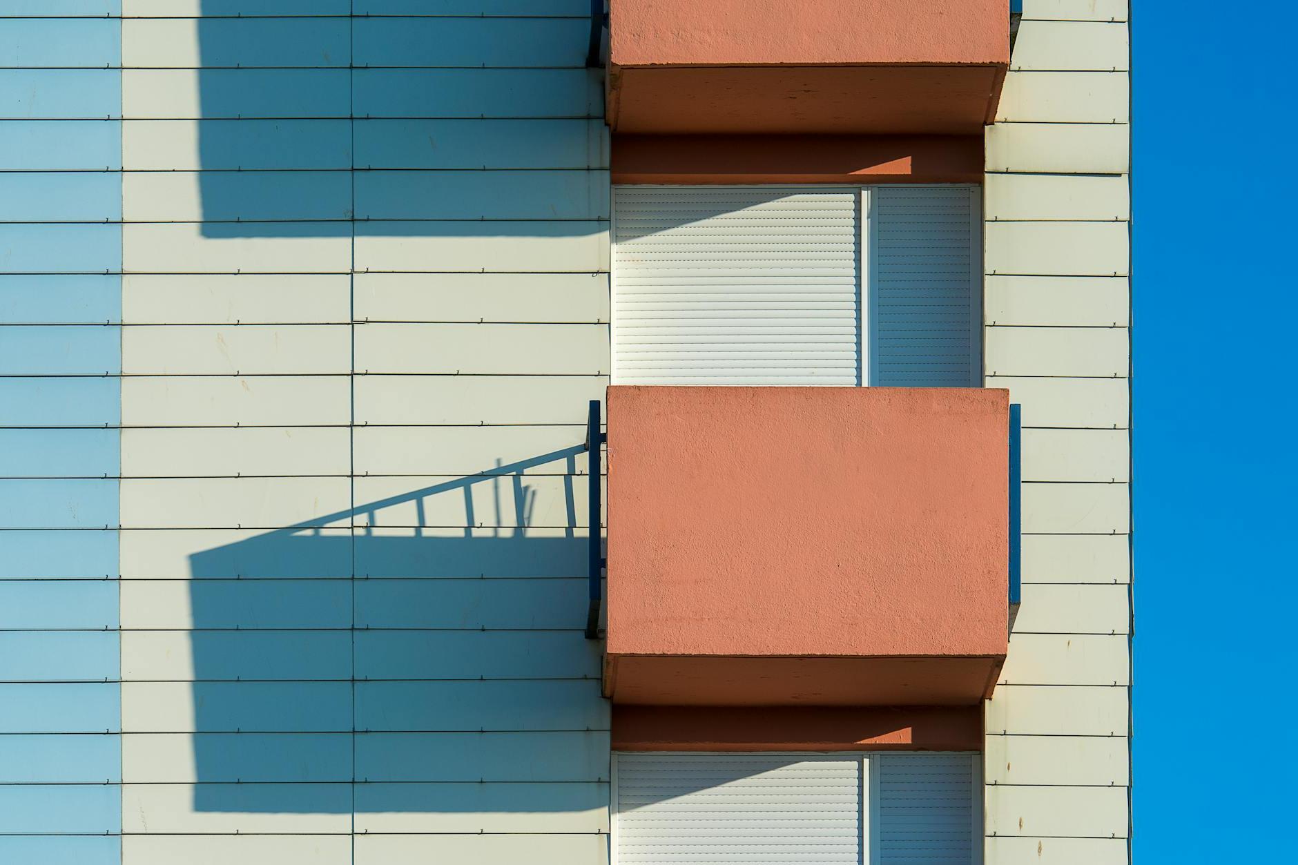 A balcony with two windows and a balcony railing