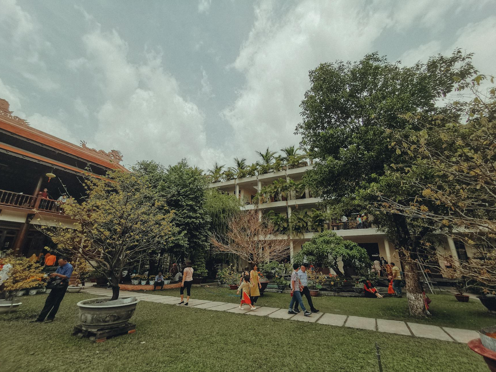 A courtyard with trees and people walking around