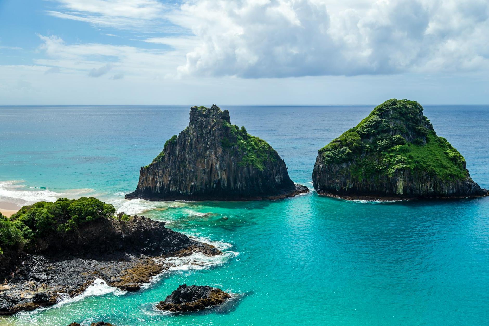 Two rocks in the ocean with blue water