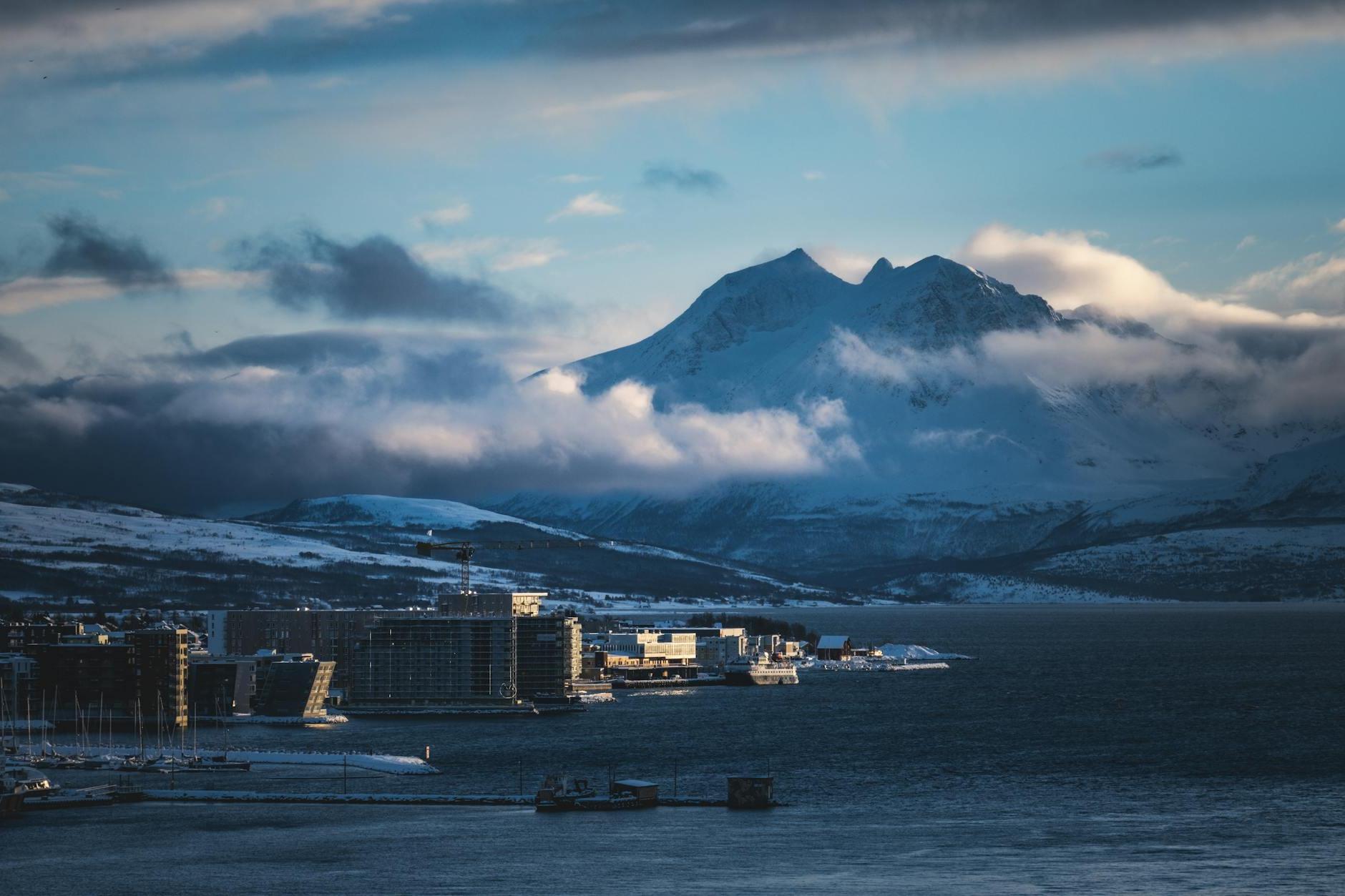 A city with mountains in the background and a harbor