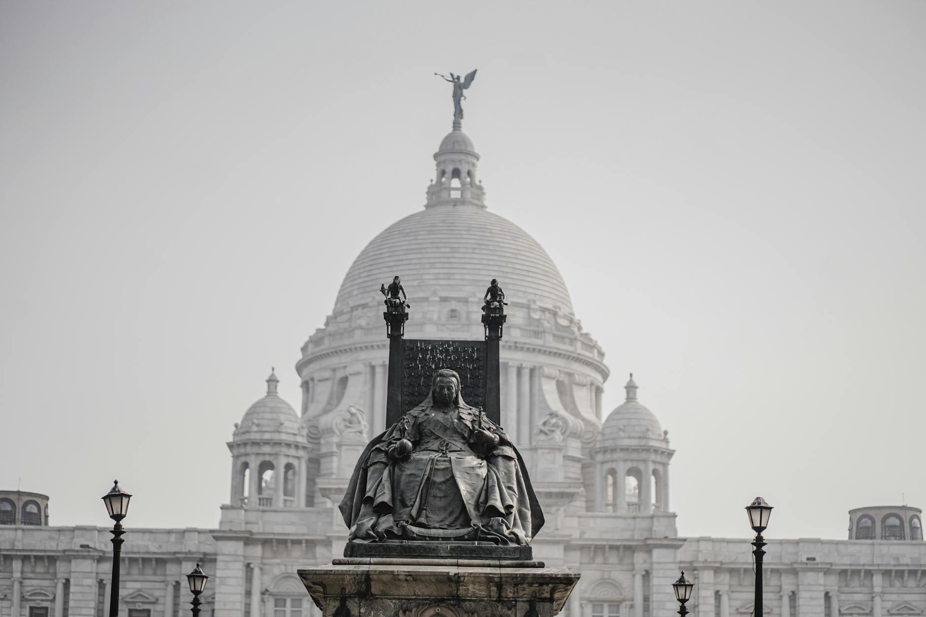 A statue of a king in front of a large building