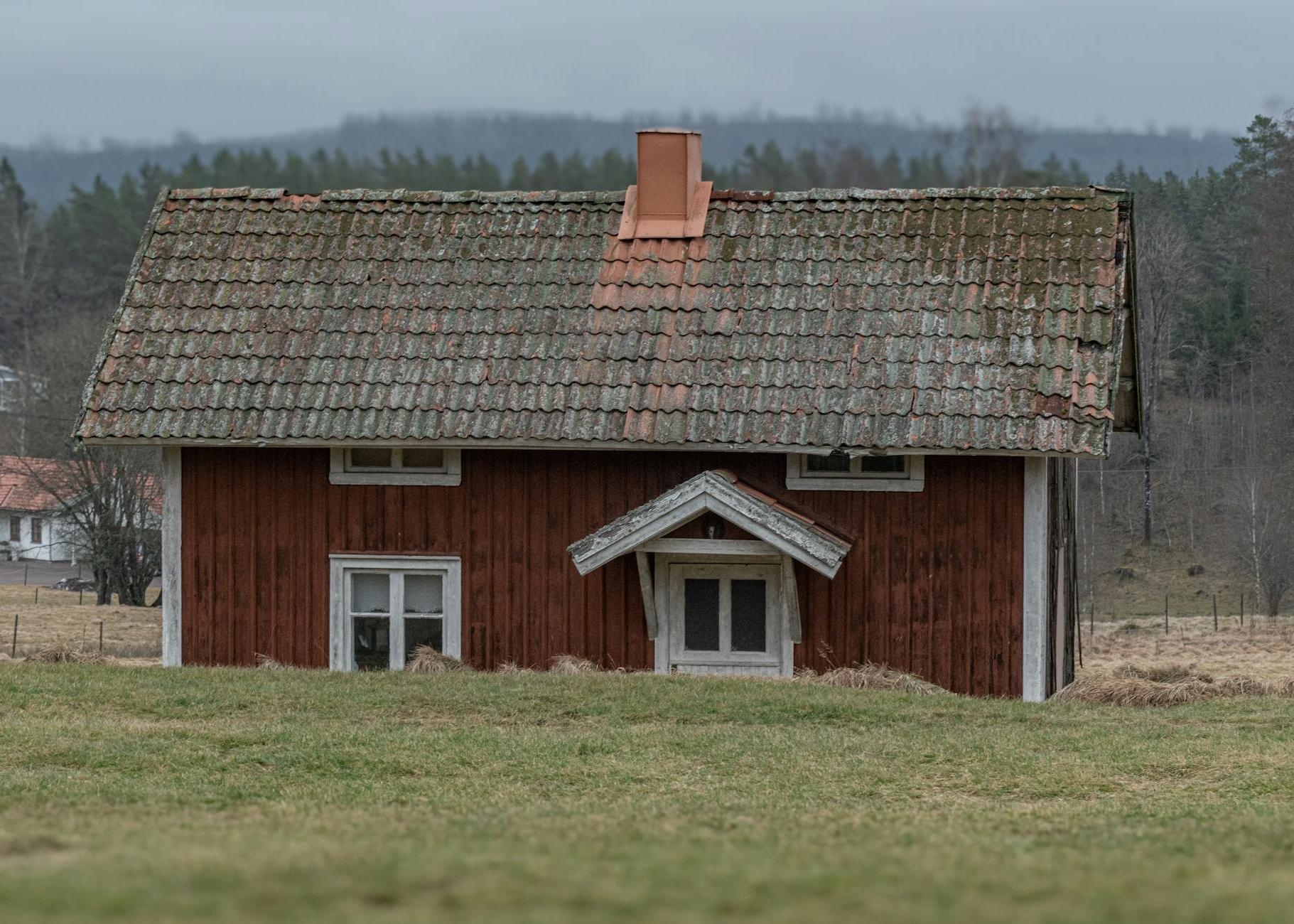 A small red house with a roof and a chimney