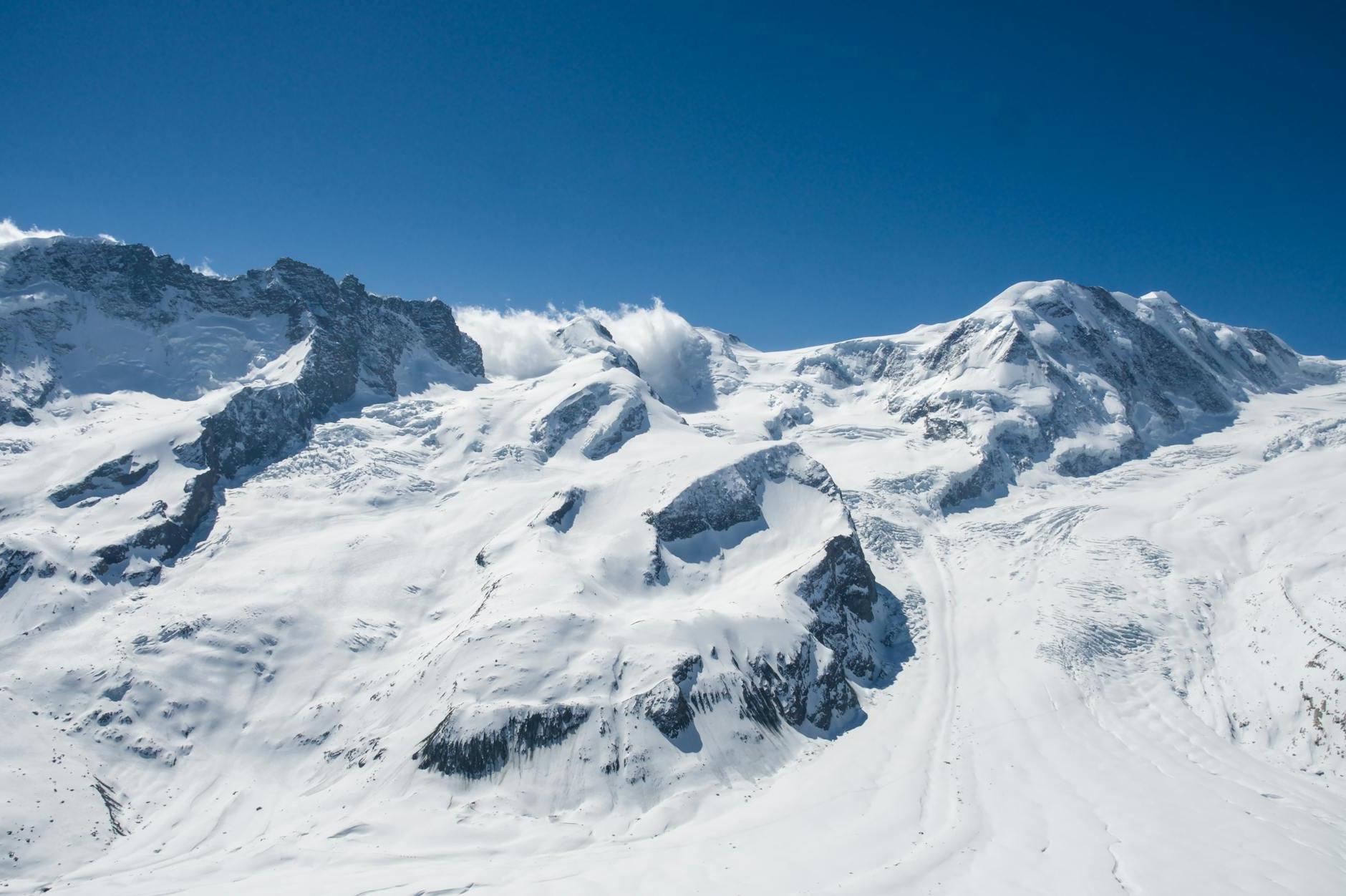 A view of a snowy mountain range with a blue sky