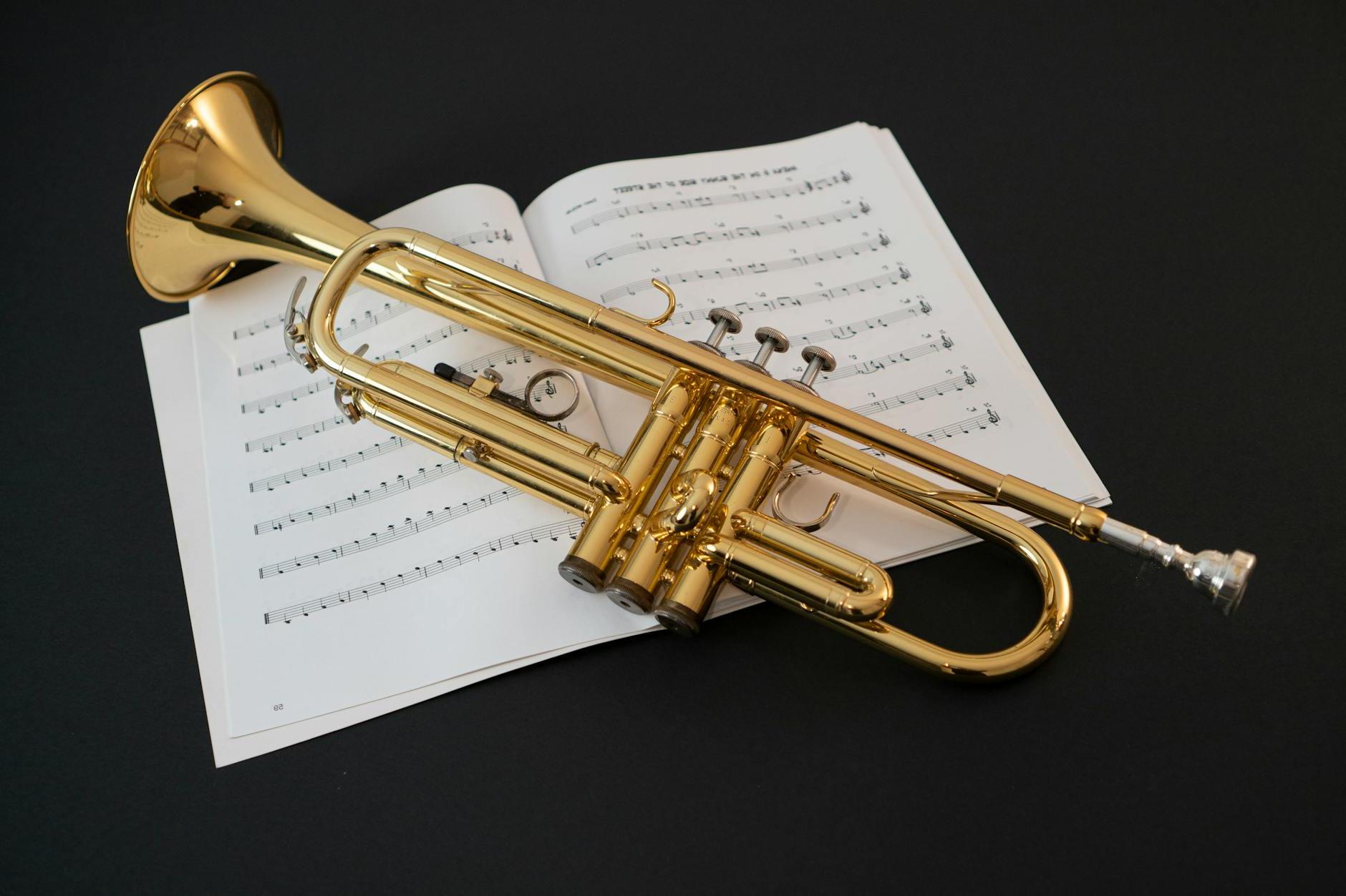 A trumpet and sheet music on a black background