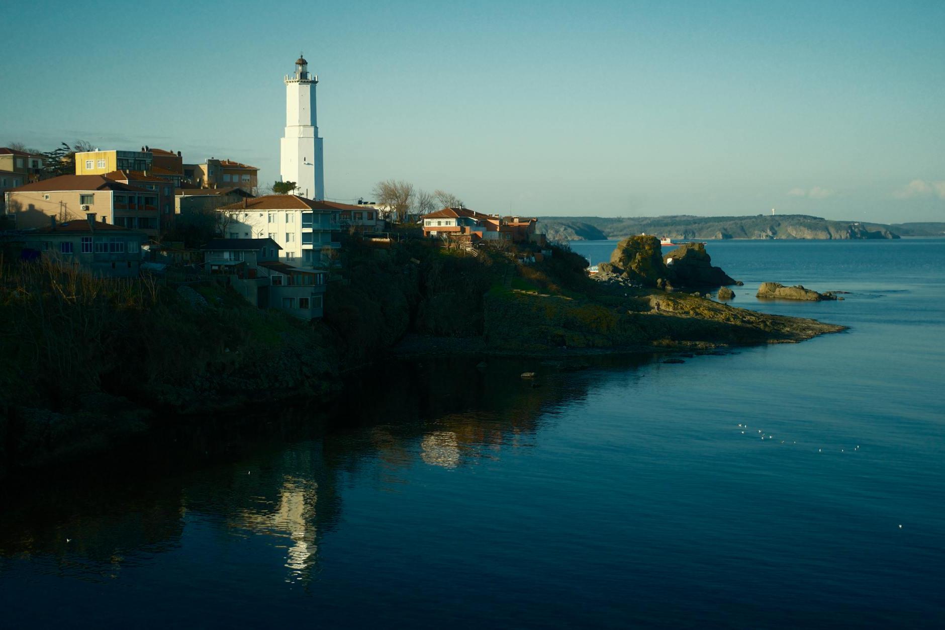 A lighthouse is seen in the distance by the water