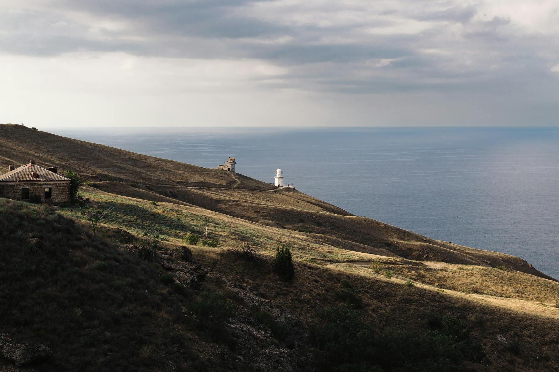 A lighthouse on a hill overlooking the ocean