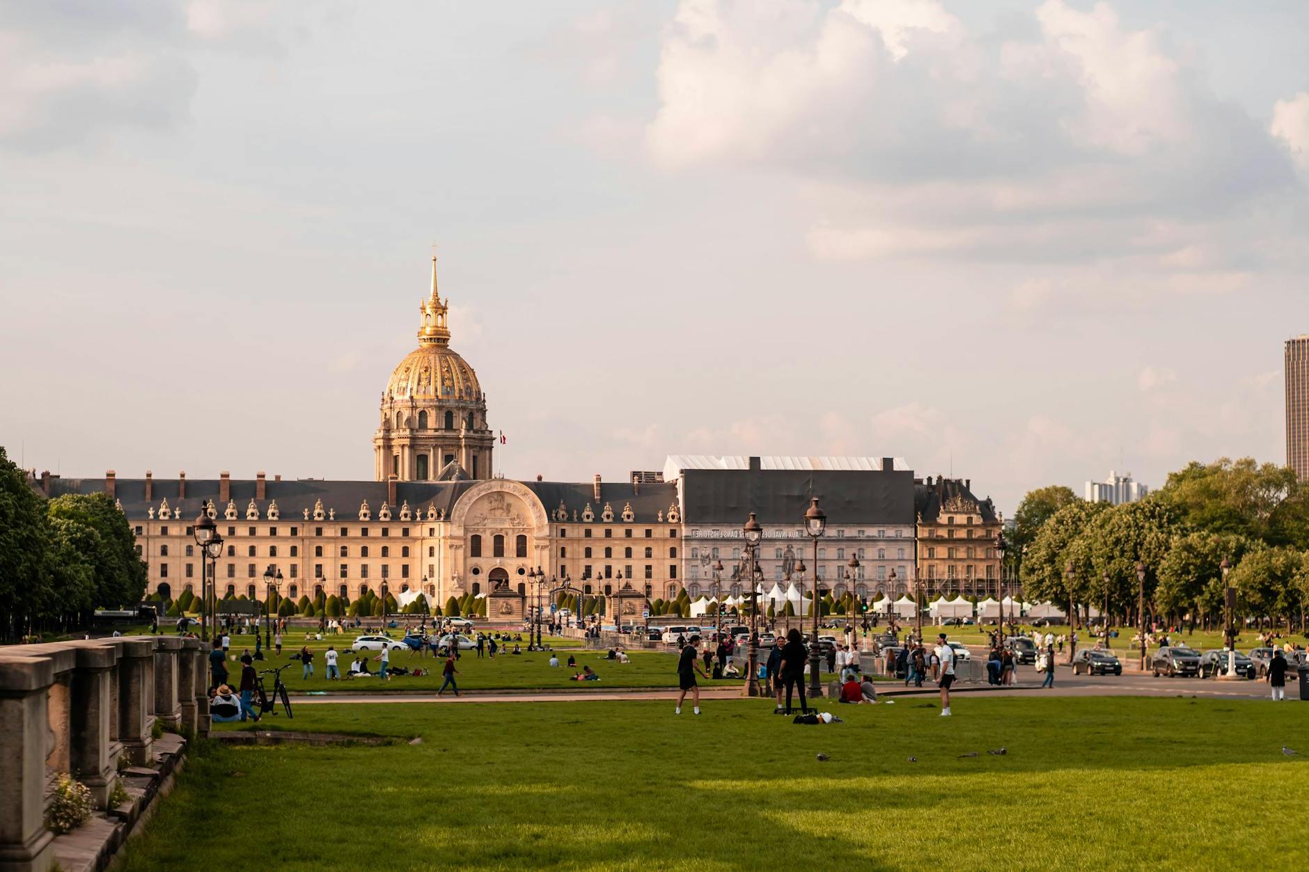 A large park with people sitting on the grass