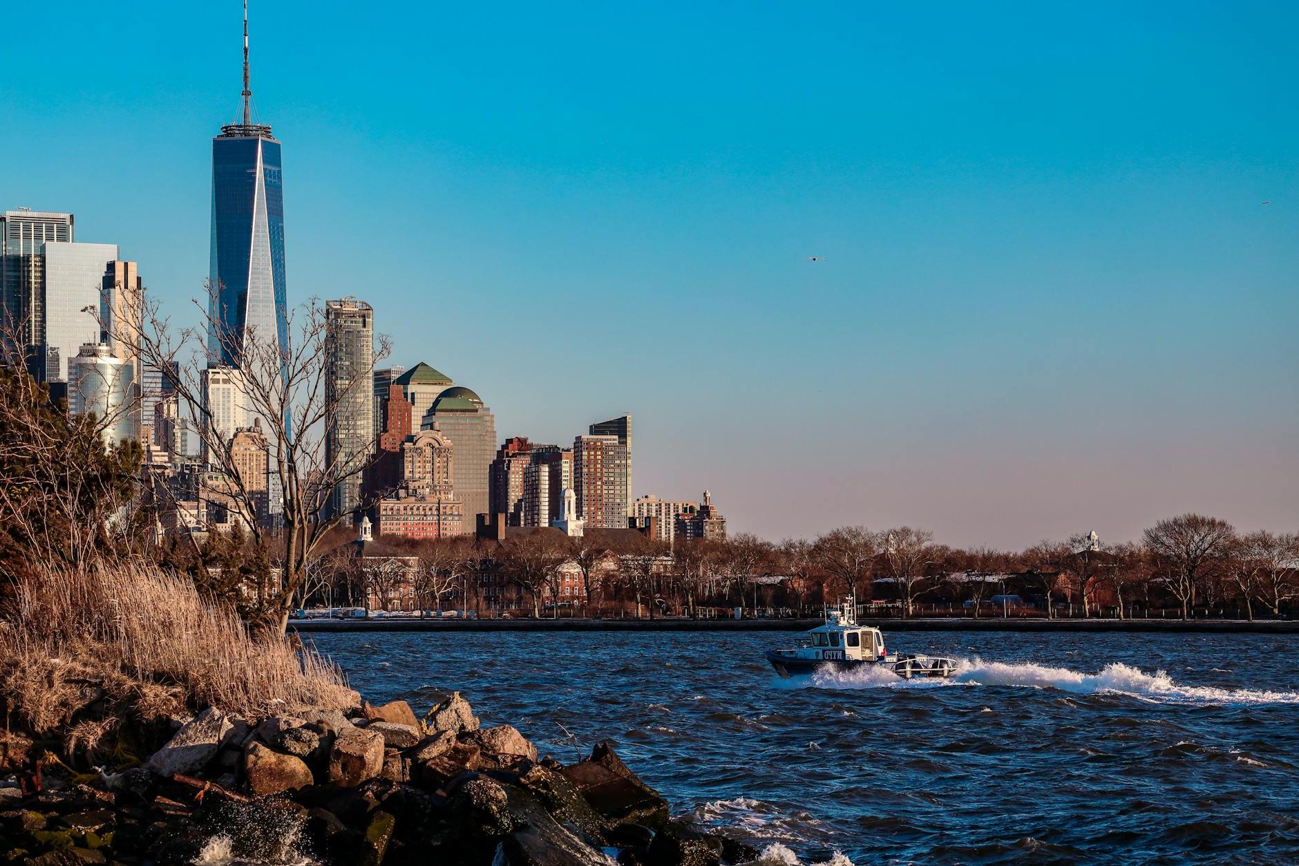 A boat is traveling through the water near the city