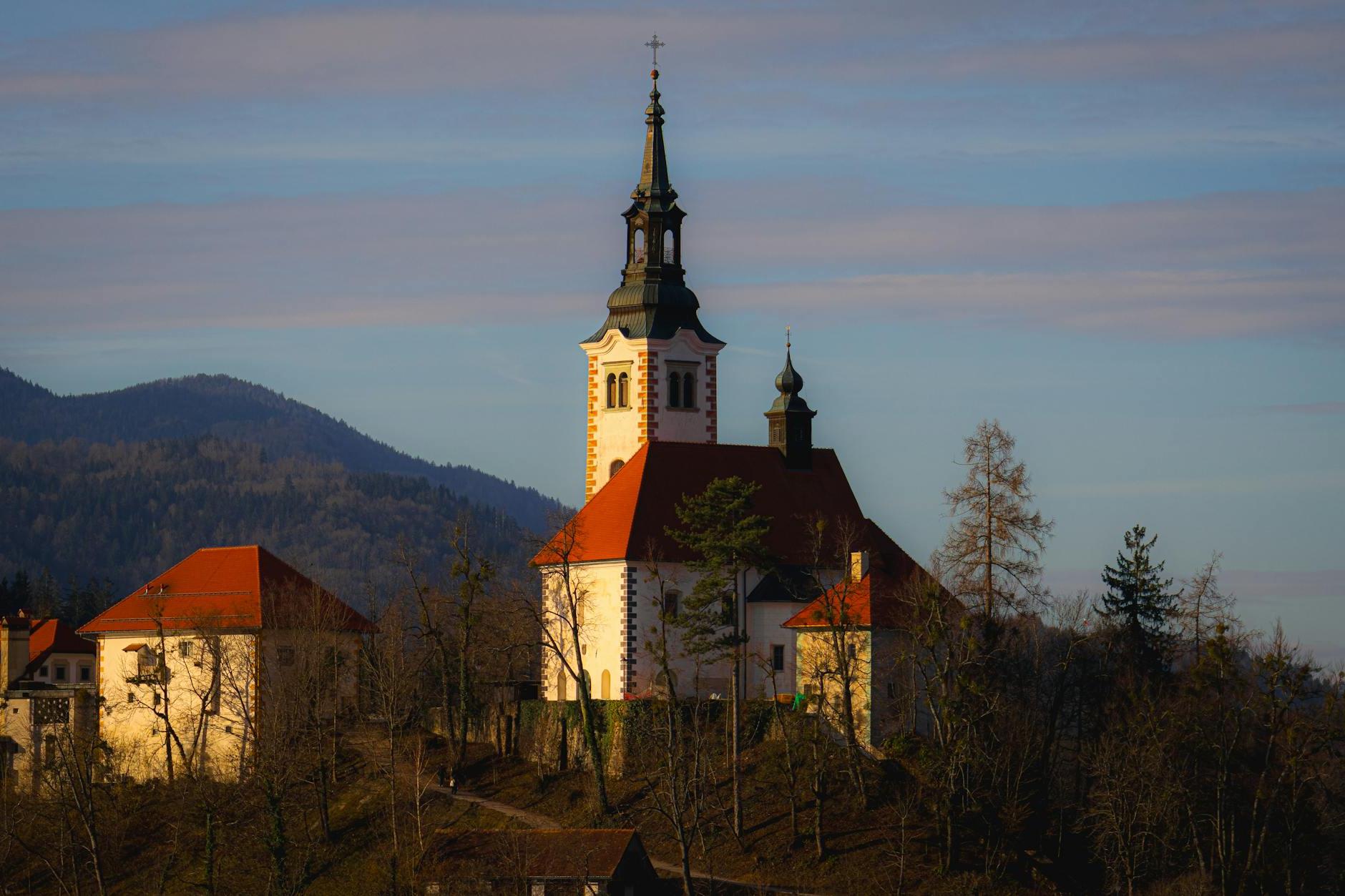 A church on top of a hill with a mountain in the background