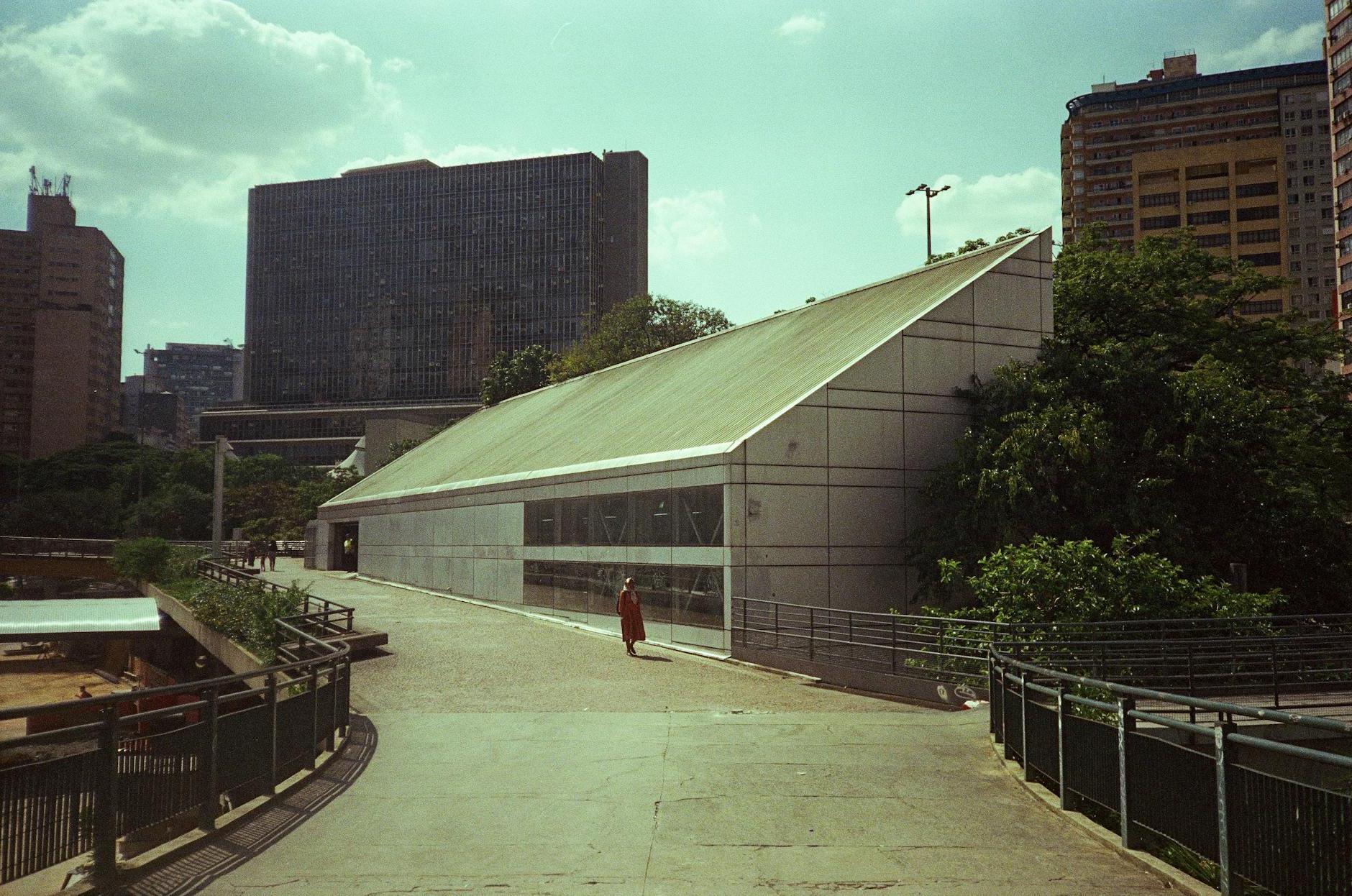 A person walking down a sidewalk next to a building