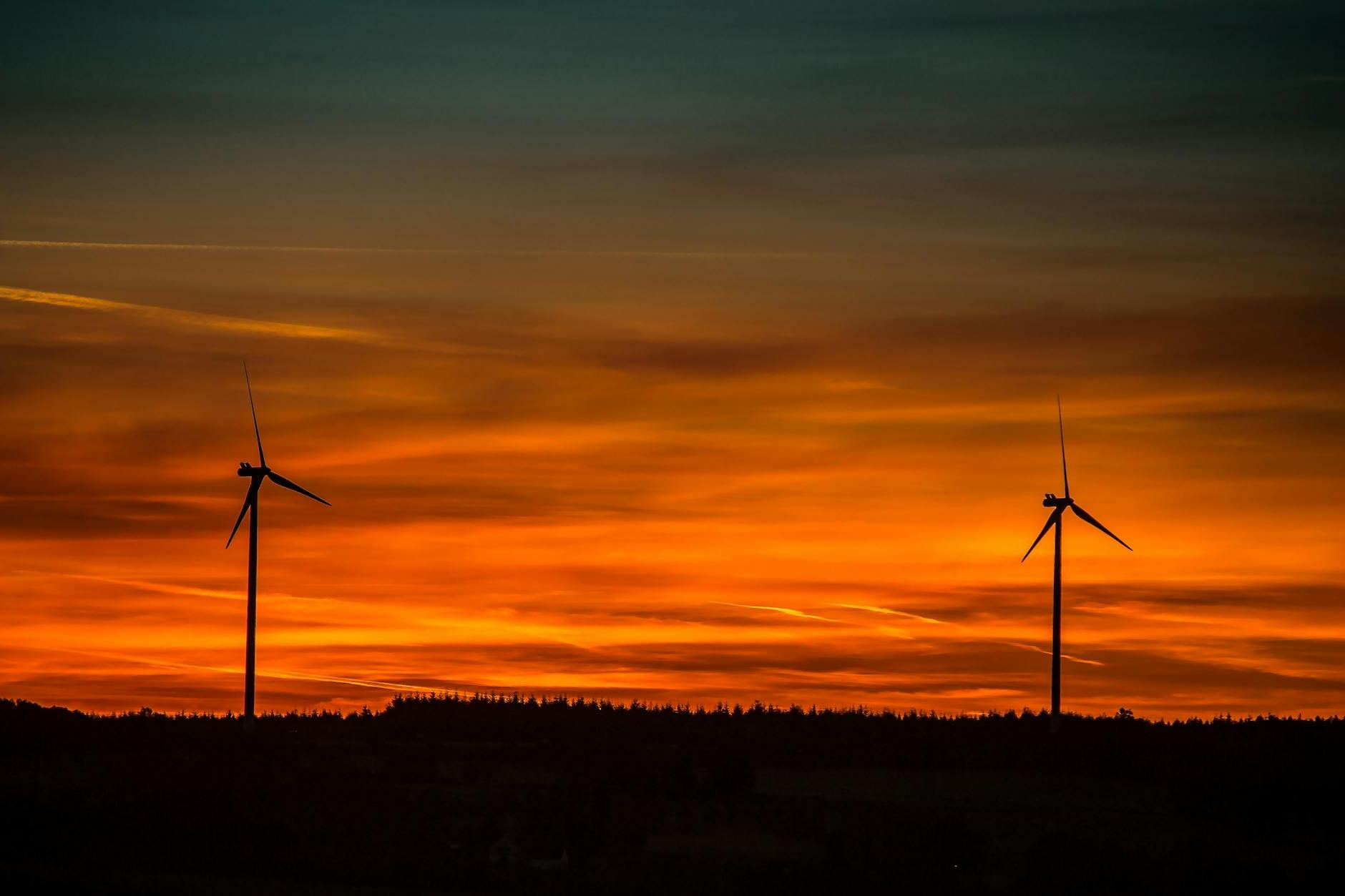 Silhouette of Windmills Under Orange Sunset