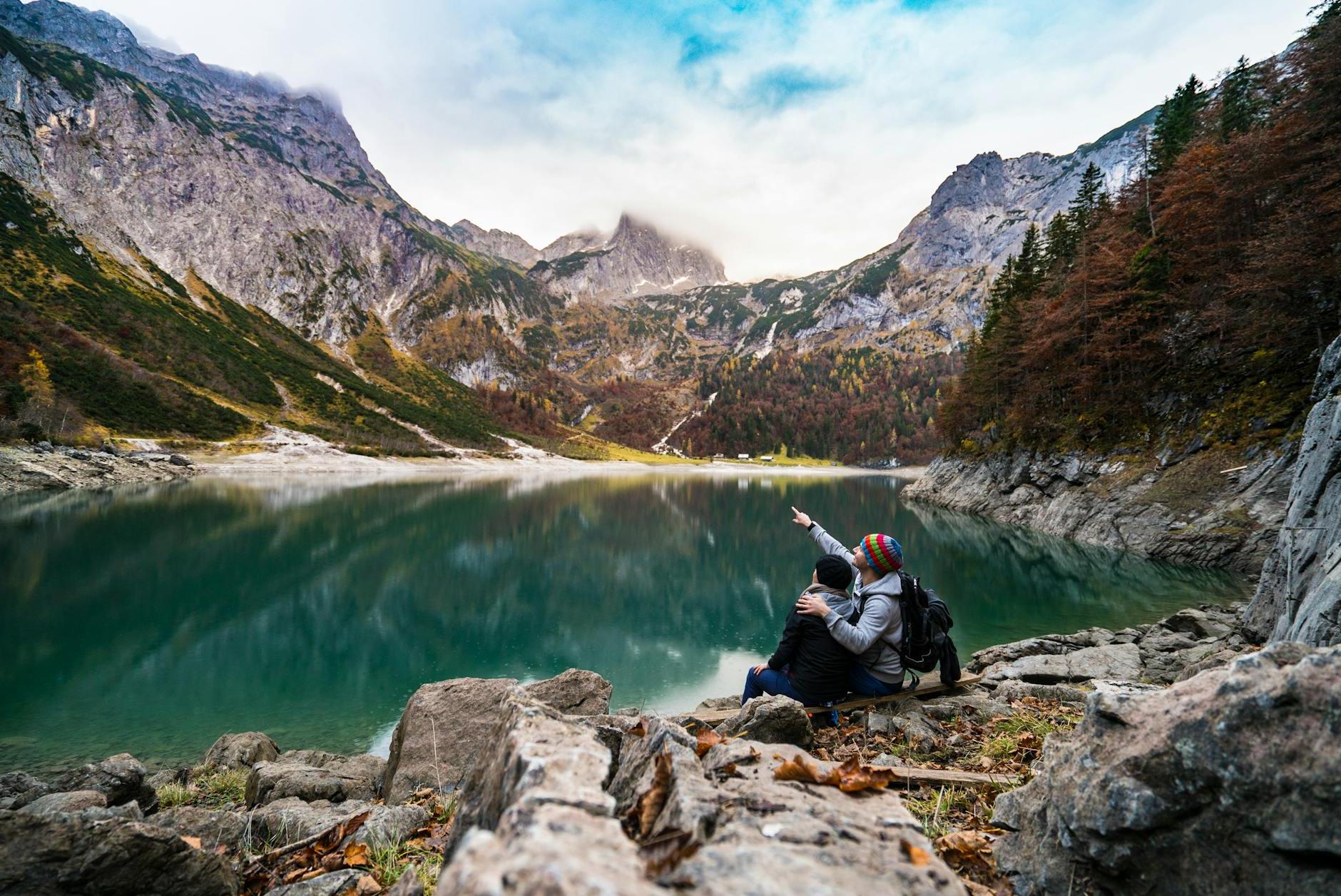 Couple Sitting on Rock Beside Lake