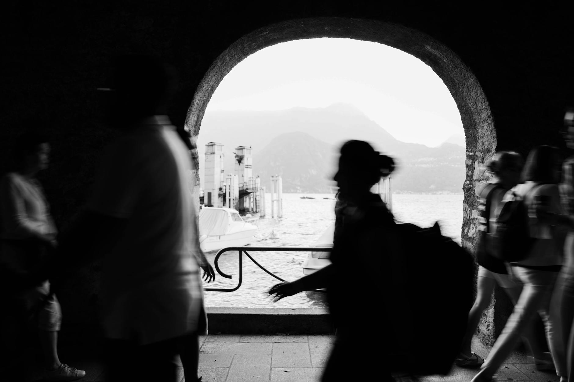 A silhouette of people walking through an archway