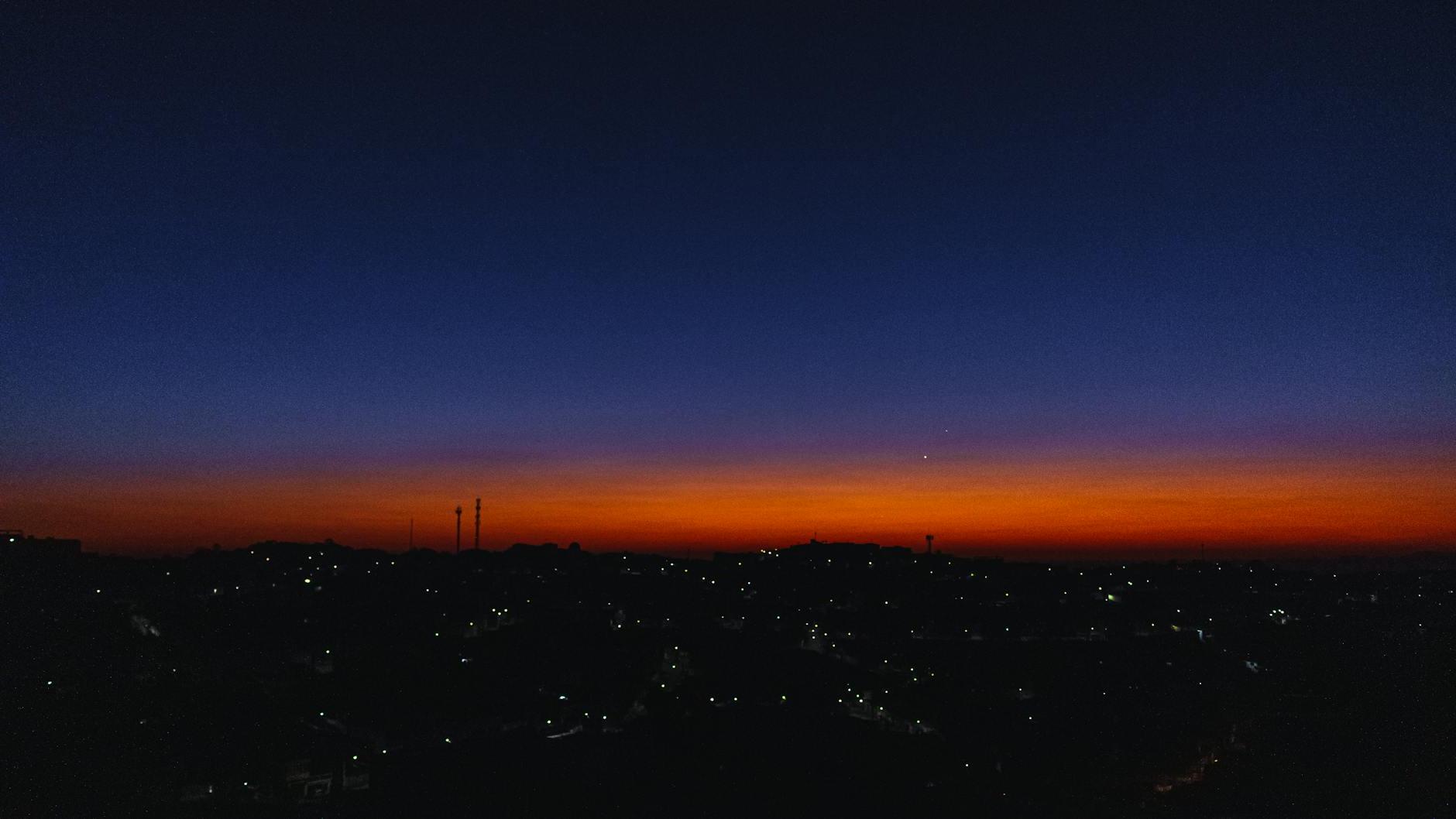 City Under Orange Sky at Night Time