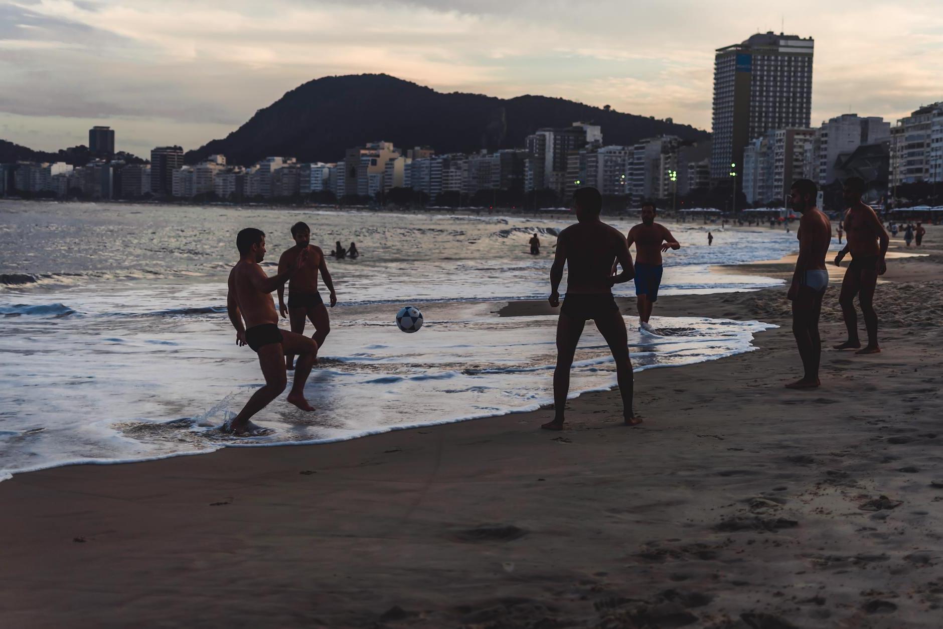 Men Playing Ball By The Seashore