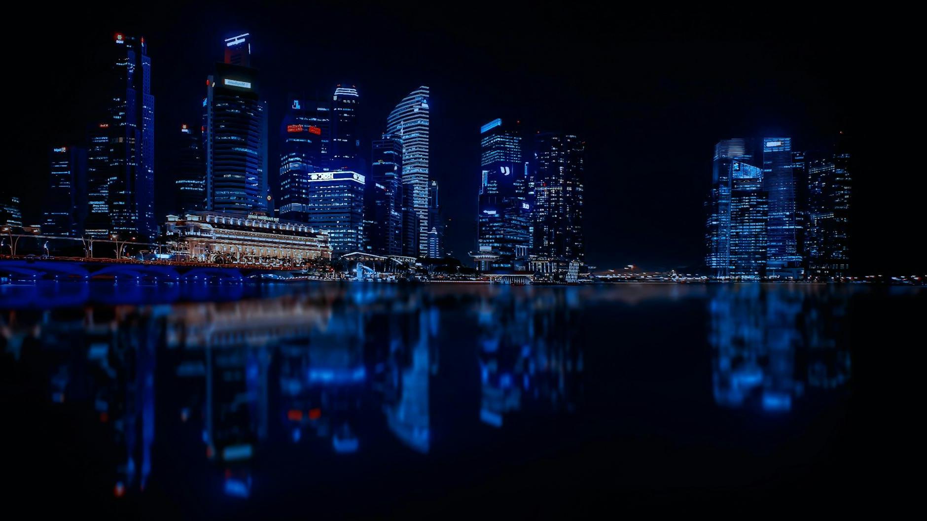 Illuminated Cityscape Against Blue Sky at Night