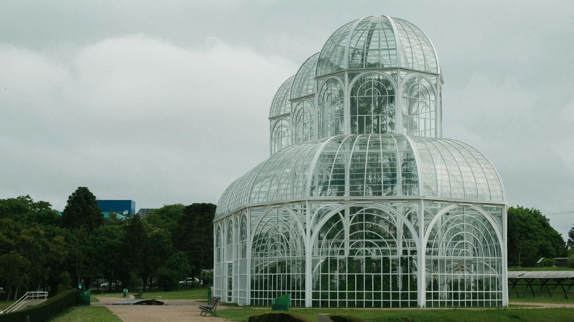 Wide Angle Shot Of White Greenhouse In The Middle of A Park