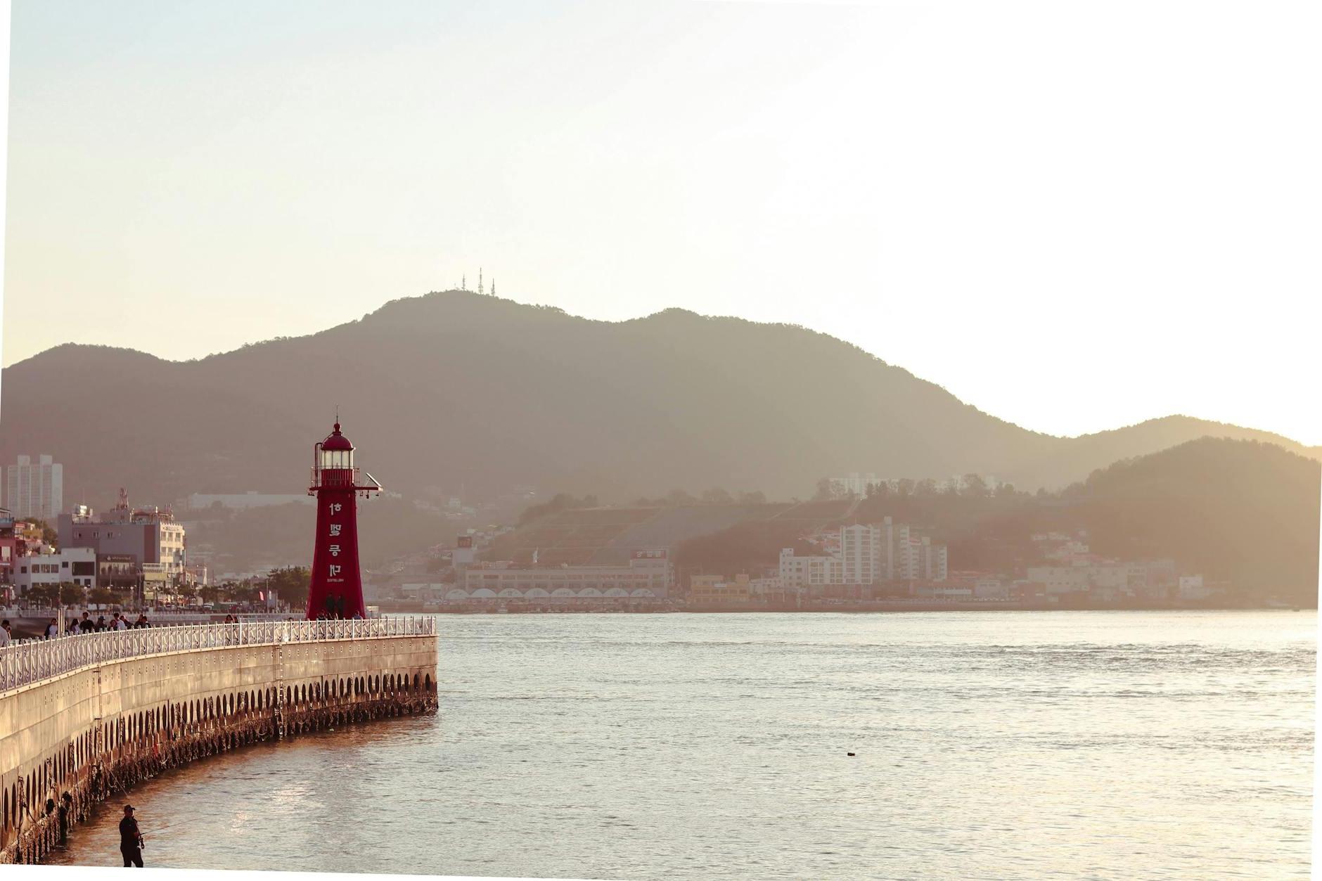 Red and White Lighthouse Near Body of Water