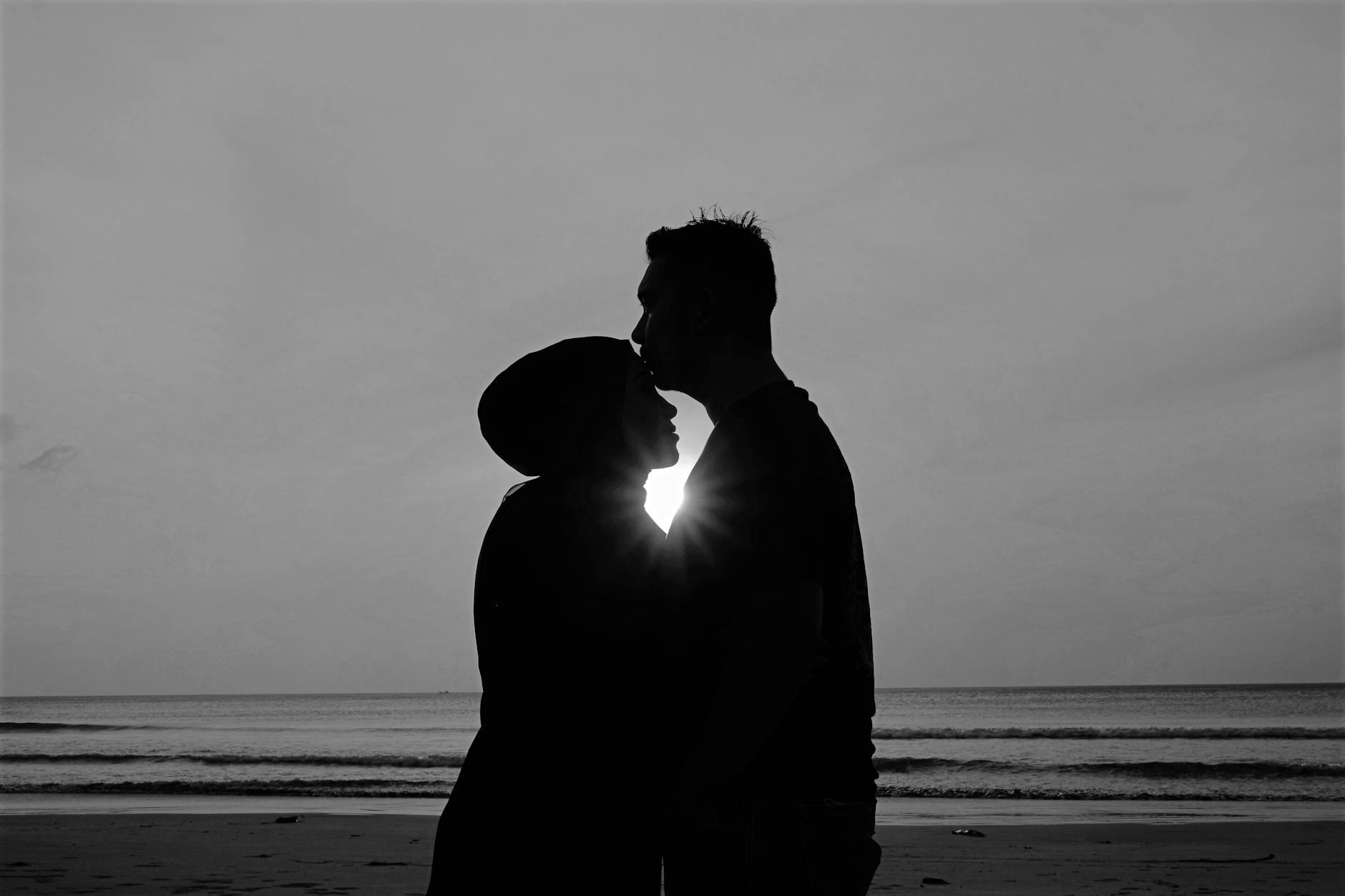 Silhouette of Man and Woman Standing on Beach