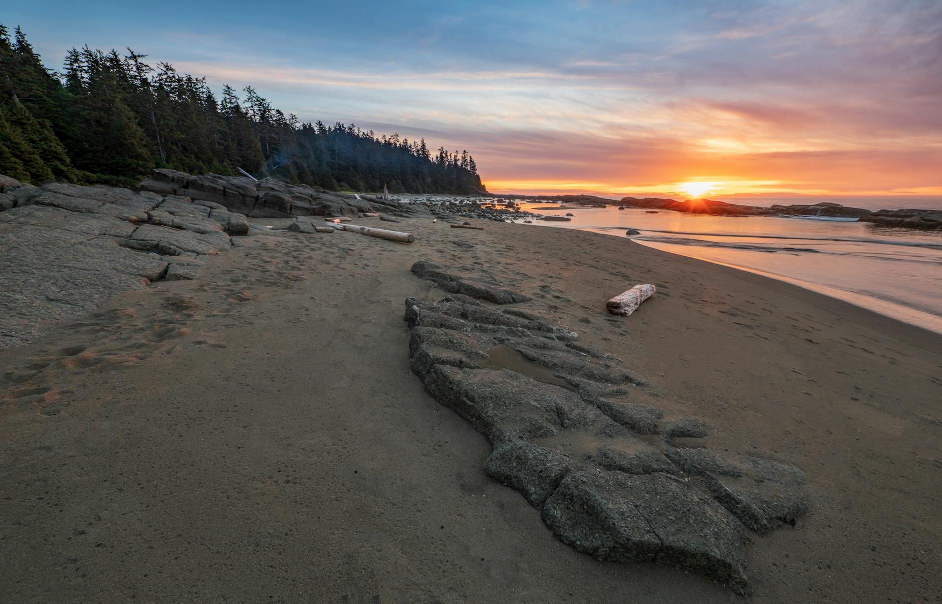 Brown Sand Near Body of Water during Sunset