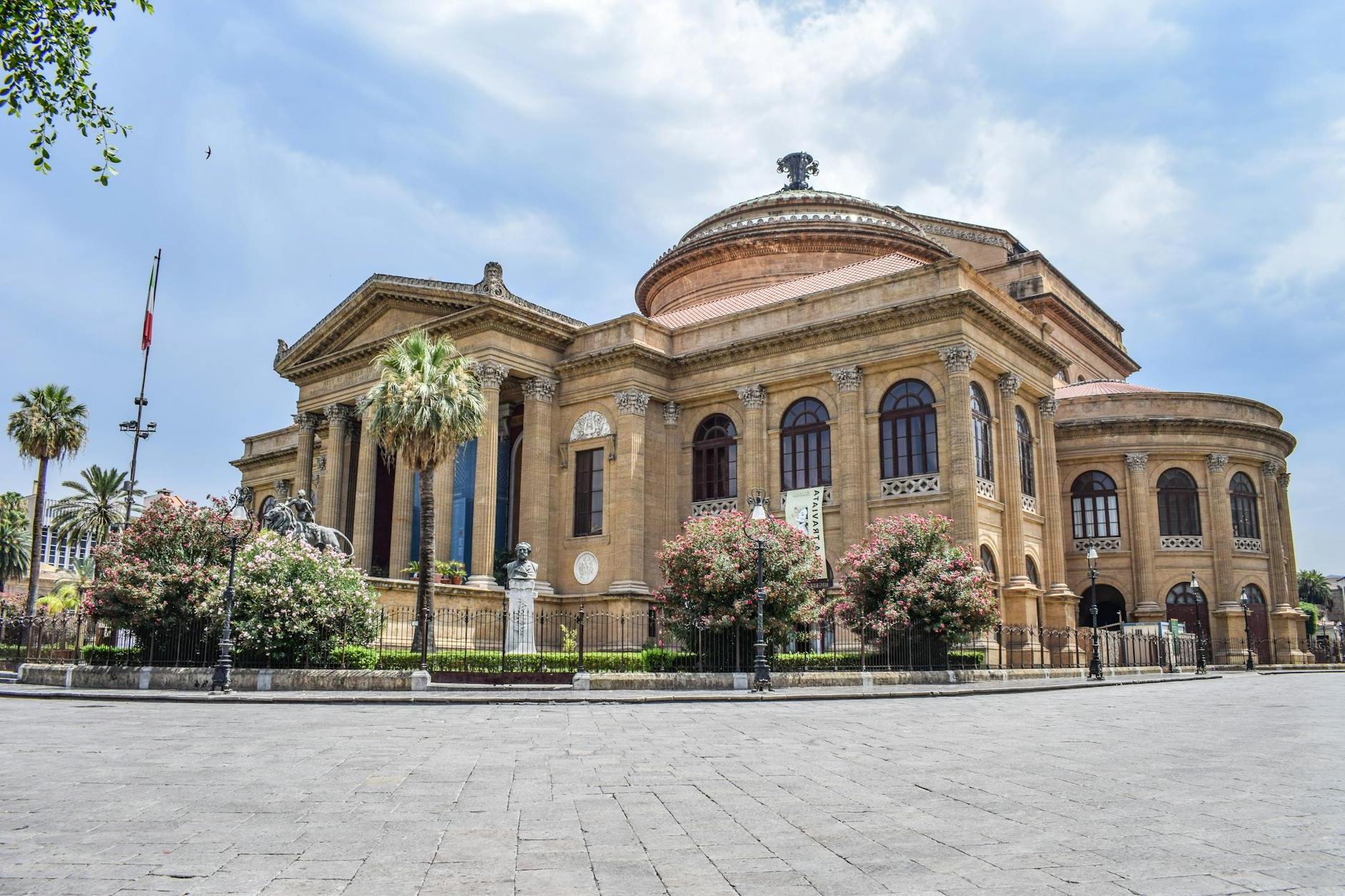 Low angle exterior of aged classic stone building of Teatro Massimo with columns and ornamental elements located square in Palermo