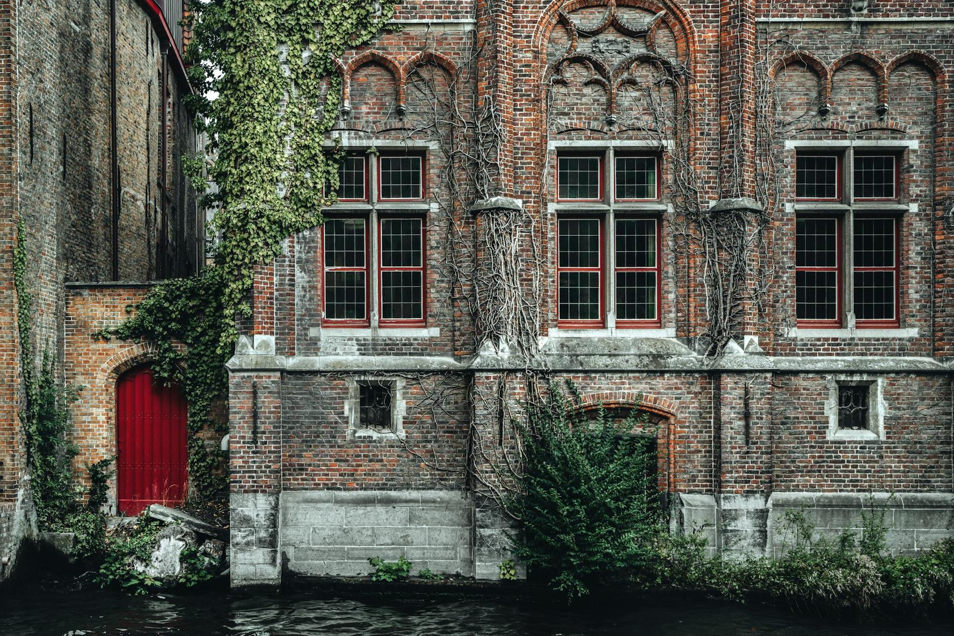 Fragment of exterior of ancient historic brick building with ornamental walls located on Steenhouwers Canal in Bruges