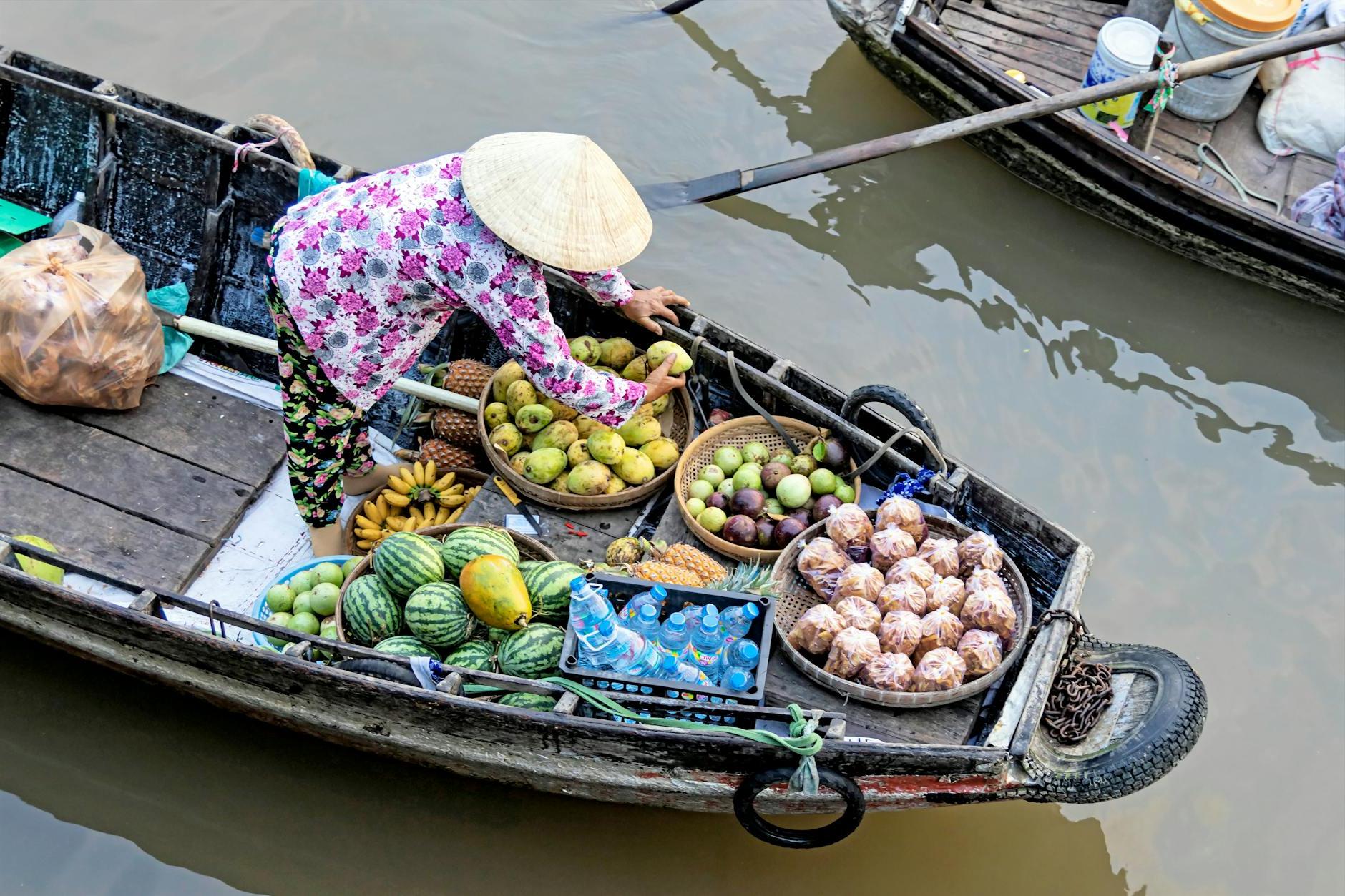 Photo of Person Selling Fruits While Standing on Boat