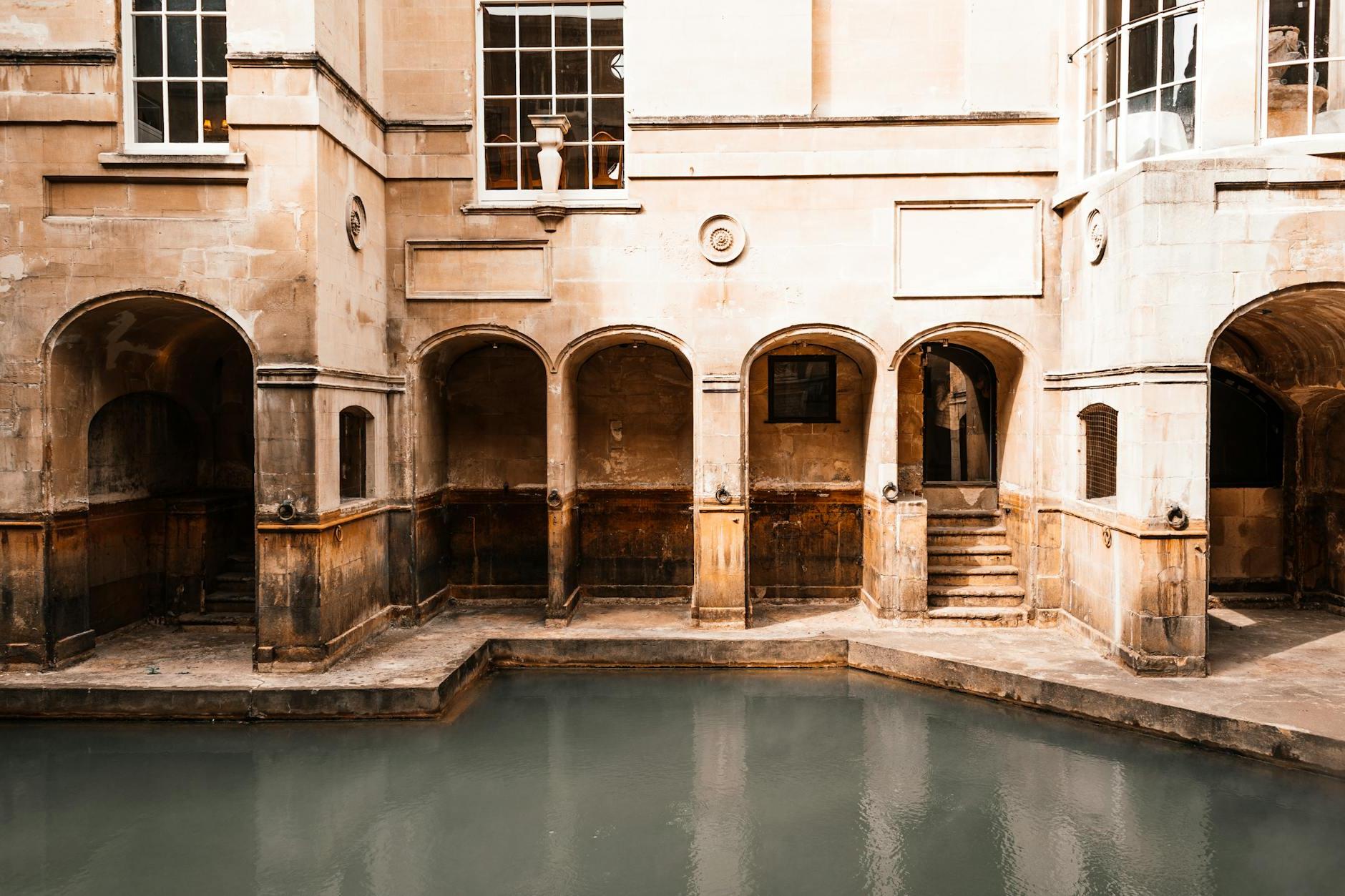 Exterior of aged mansion with shabby walls and arched passages located near water canal in old city in sunny street