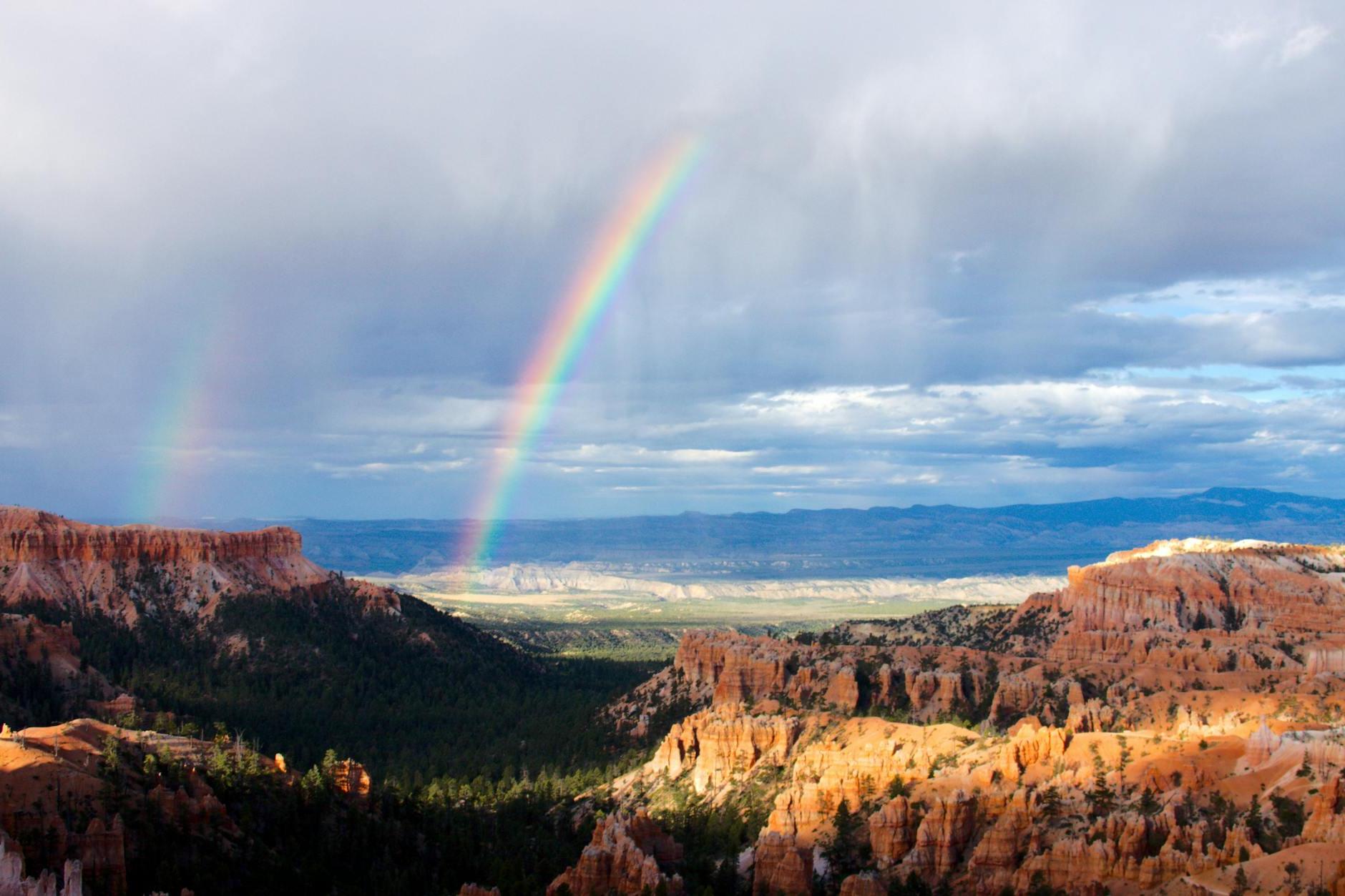 Rainbow Reflects Near Mountains