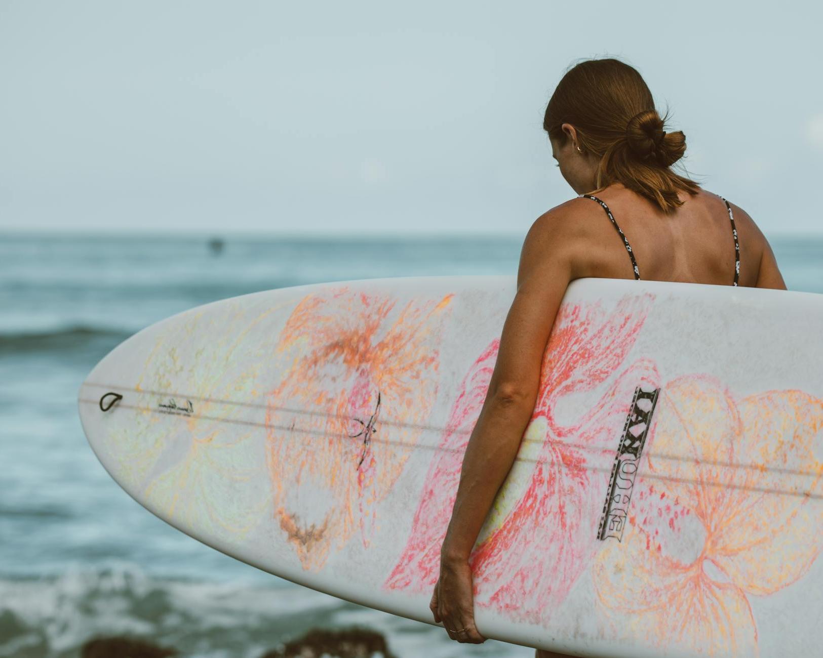 Woman in Pink and White Surfboard on Sea