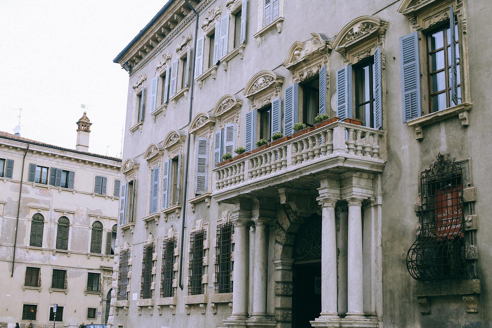 Facade of ancient classic building with balcony and columns located in old city