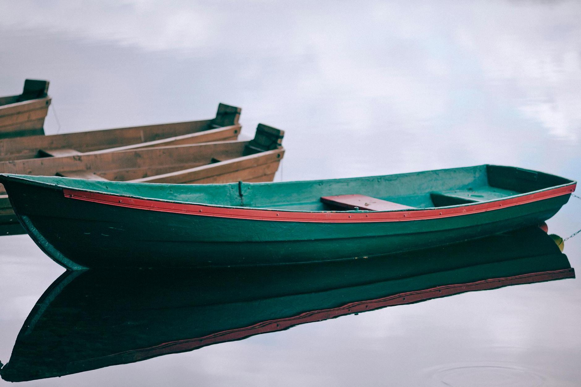 Wooden boats moored on calm pond water