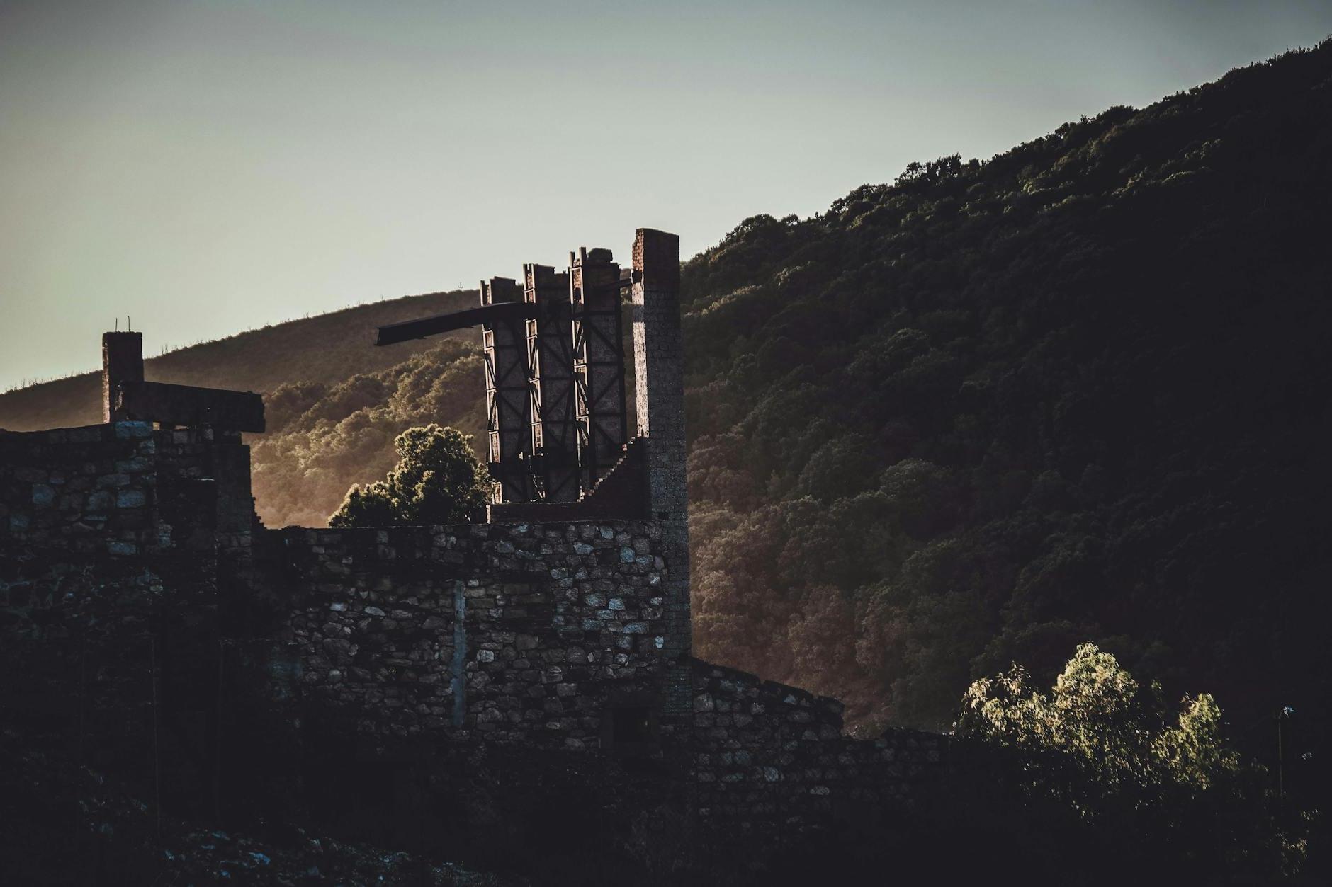 Old ruined fort in mountainous valley at sundown