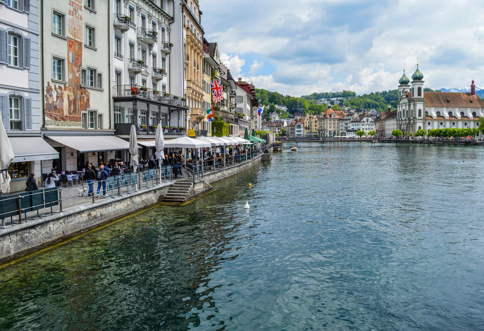 Calm river channel located in town with colorful buildings under cloudy sky in daytime