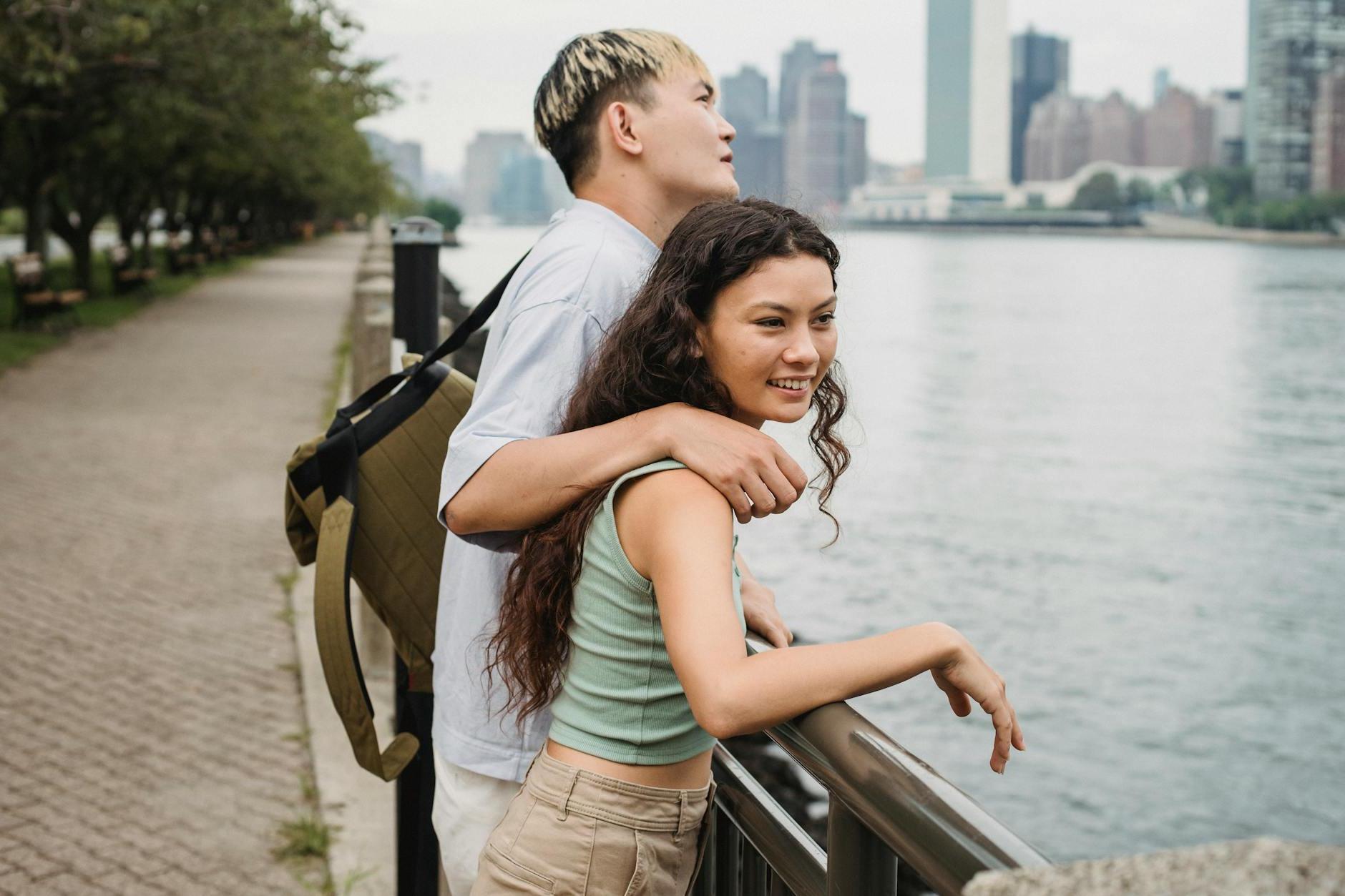 Positive couple spending time together on embankment