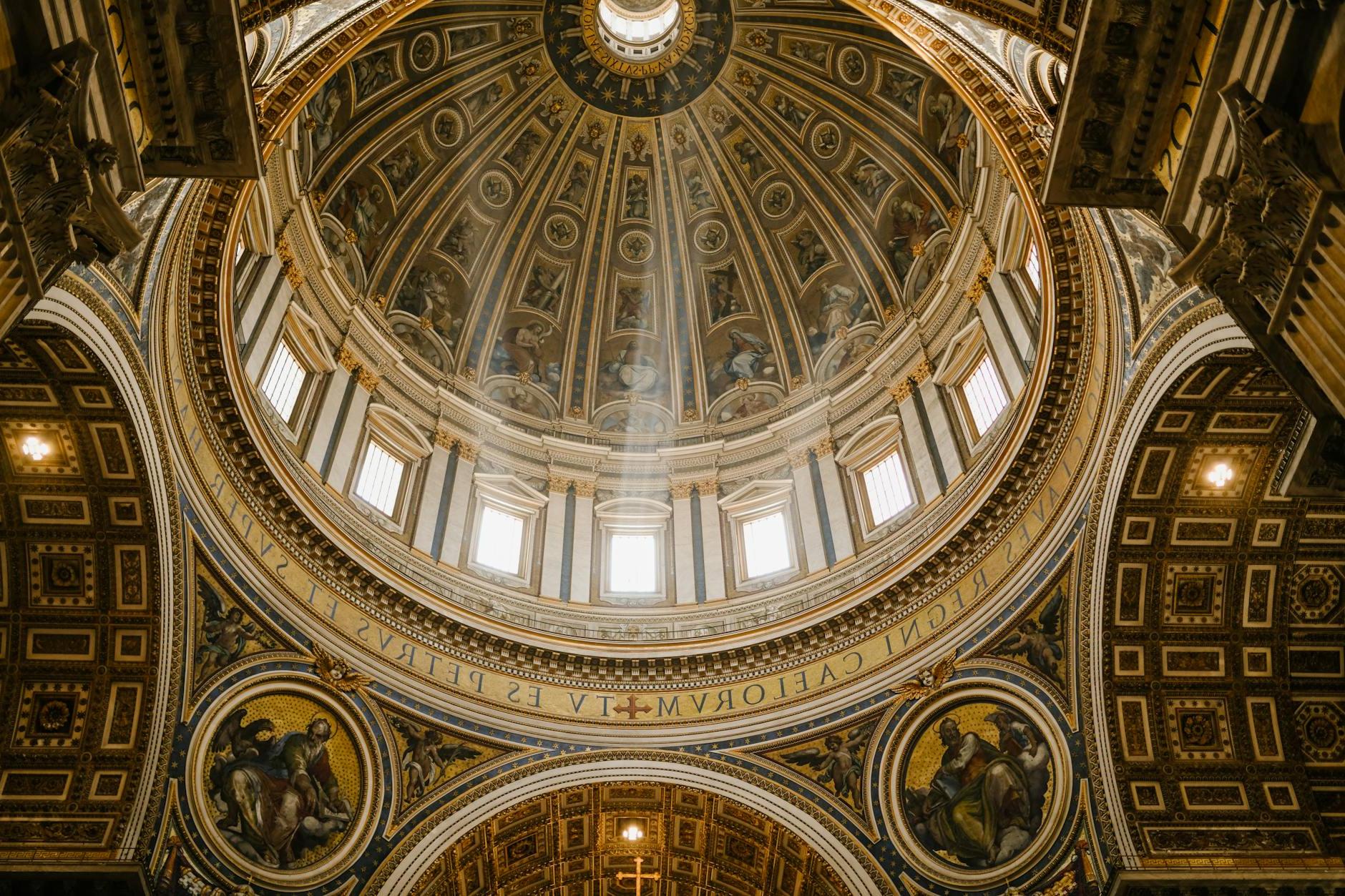 Low angle impressive design of dome with fresco paintings and golden ornamental elements in famous Catholic Saint Peters Basilica in Rome