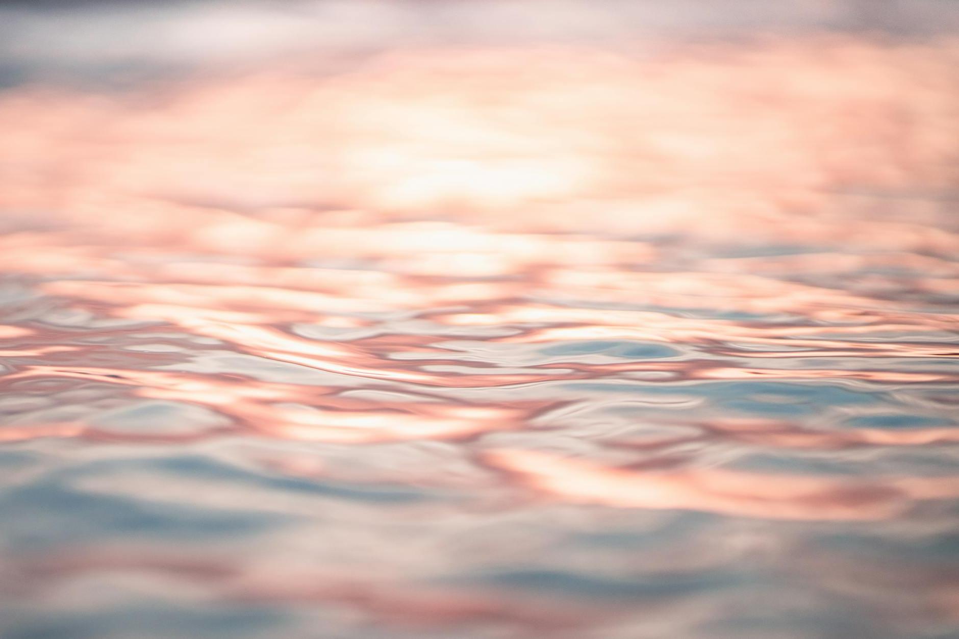 Rippling seawater reflecting pink evening sky