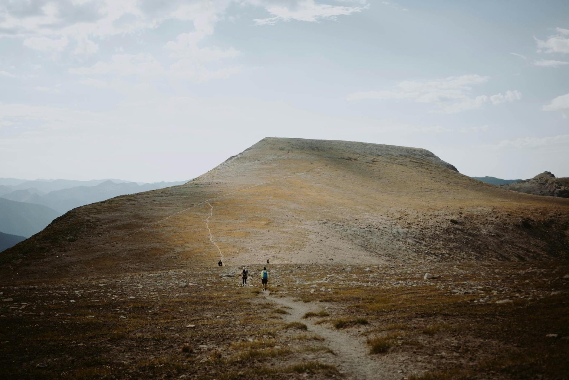 Distant travelers walking on hillside