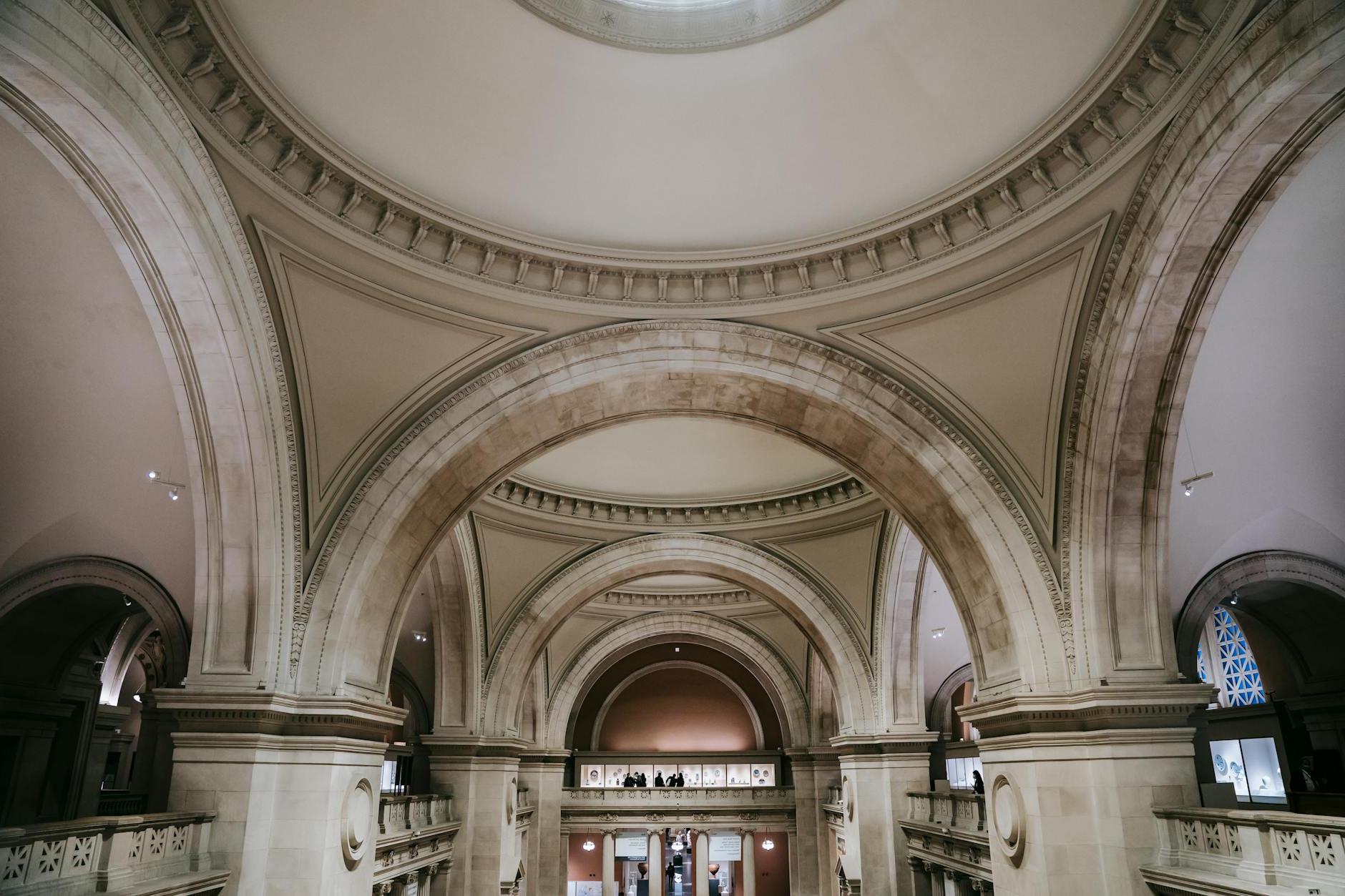 Interior of majestic spacious classic building with arched passages and ornamental elements on ceiling