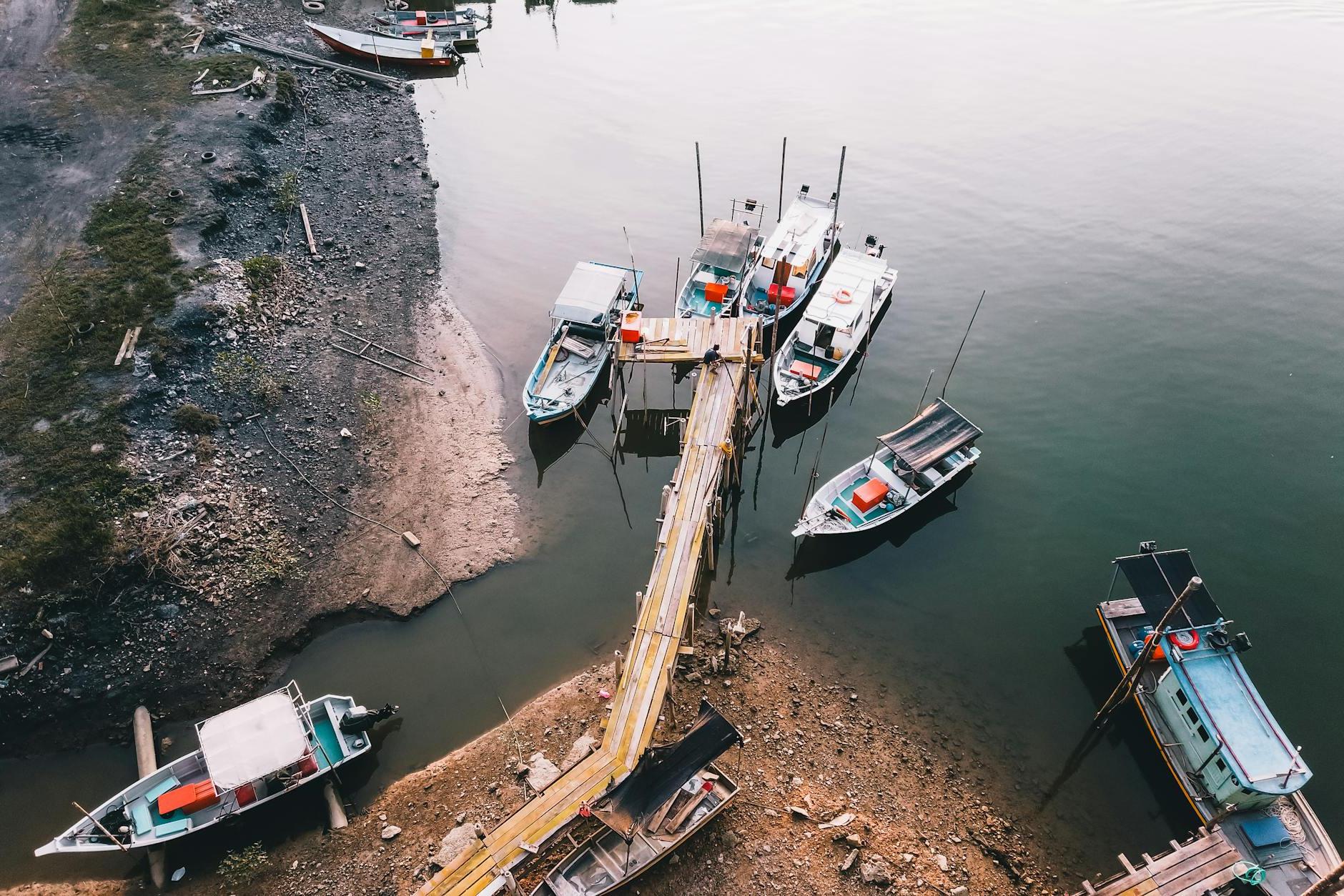 Boats moored on sea near rural pier