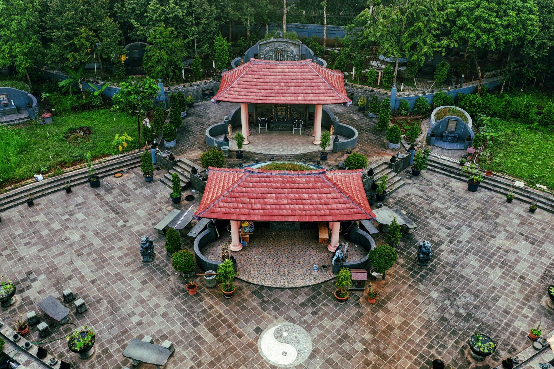 From above of Chinese pagoda with red roofs placed in green park with stylish landscape design in daylight