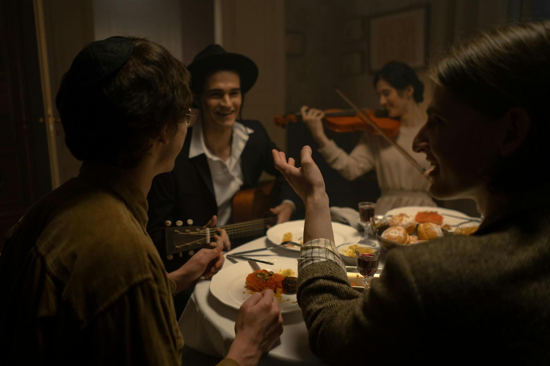 People Seated At A Dining Table Celebrating Hanukkah