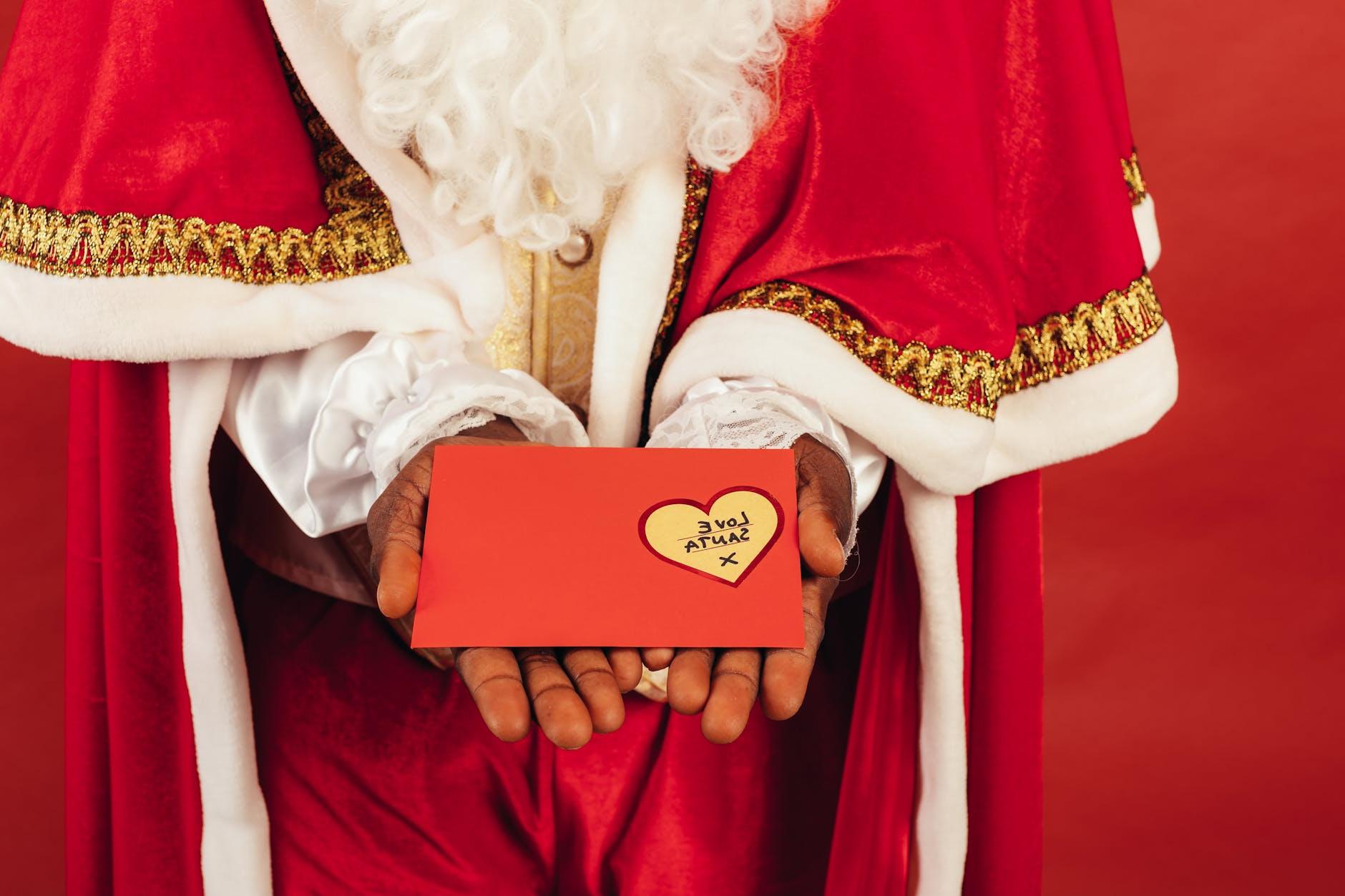 Person Wearing Santa Claus Outfit While Holding Christmas Letter