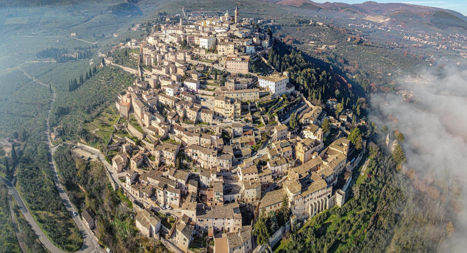 Drone view of medieval old San Marino city built on lush verdant hill in spacious valley