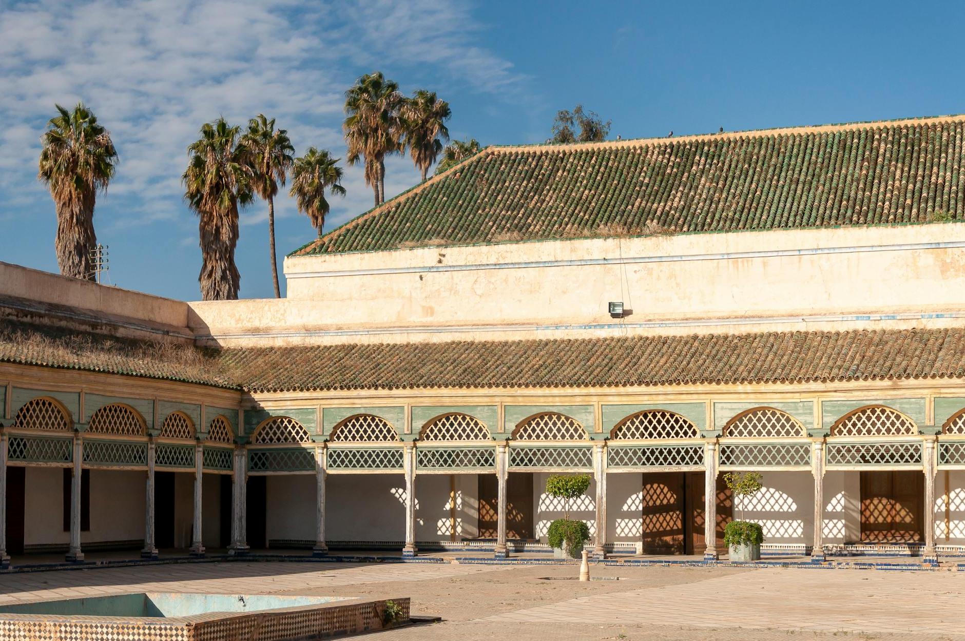 Grand Courtyard of aged historical Bahia Palace with arched passage located against blue sky in Marrakesh